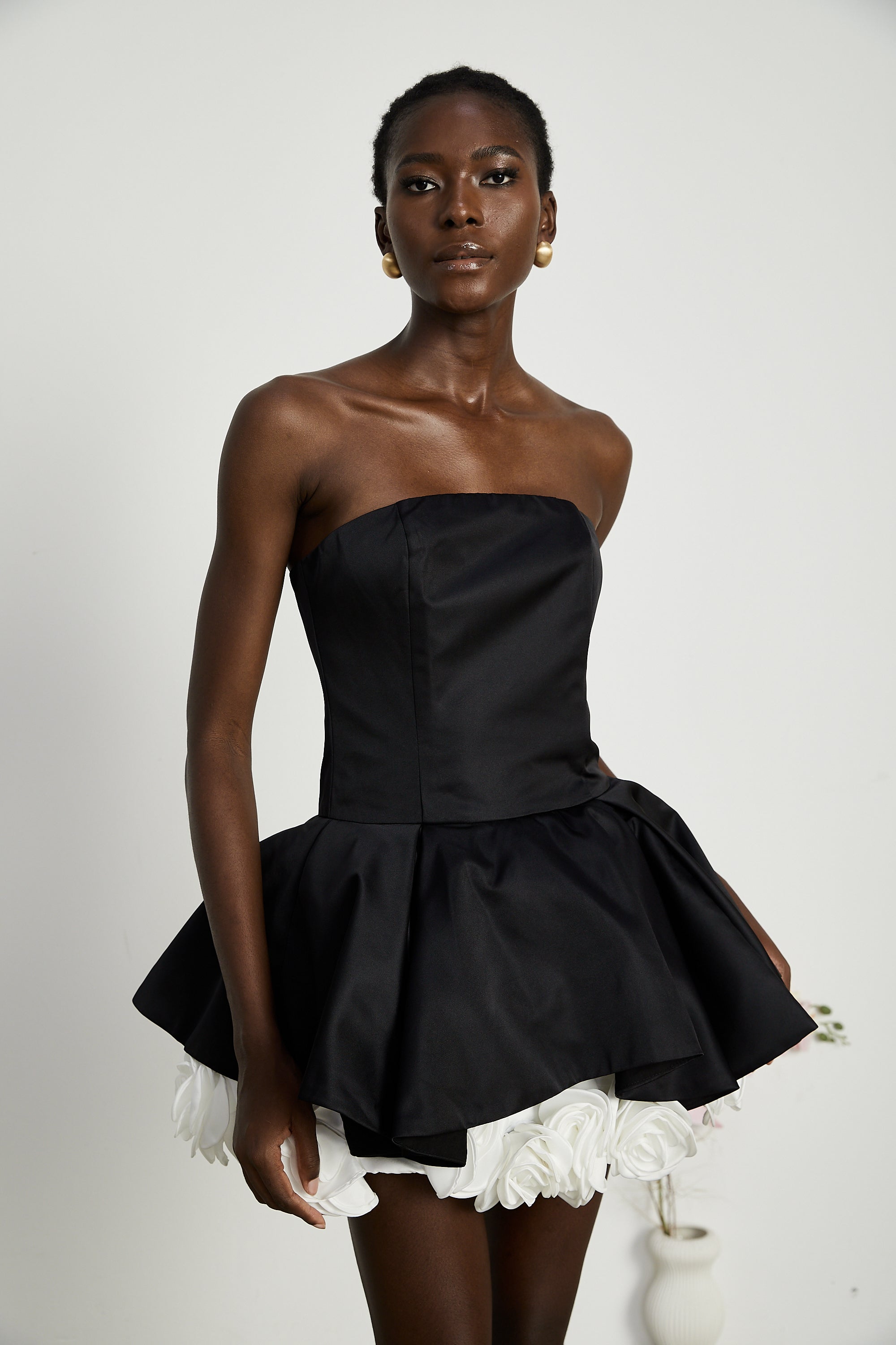 فستان لوسي الأسود القصير بدون حمالات مع طبقات من بتلات الزهور