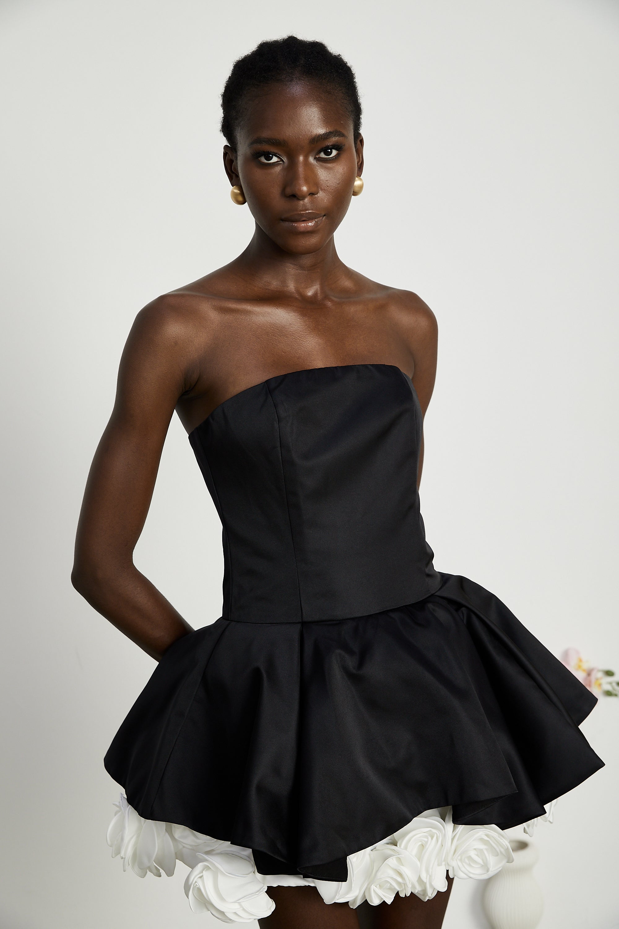 فستان لوسي الأسود القصير بدون حمالات مع طبقات من بتلات الزهور