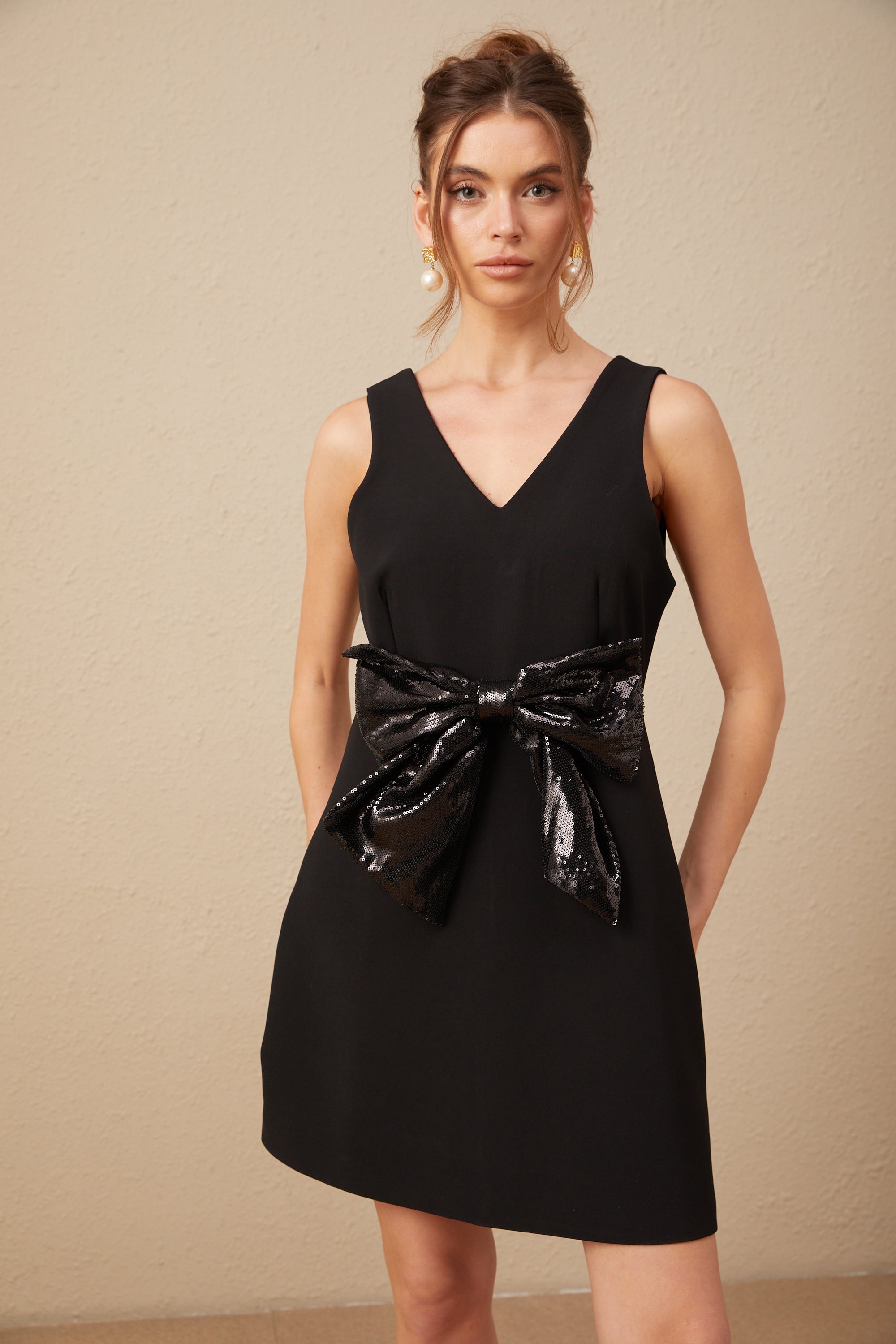 فستان ميني روجان بأكمام مكشكشة وياقة على شكل حرف V مزين بالترتر باللون الأسود (بيع نهائي - الولايات المتحدة فقط)