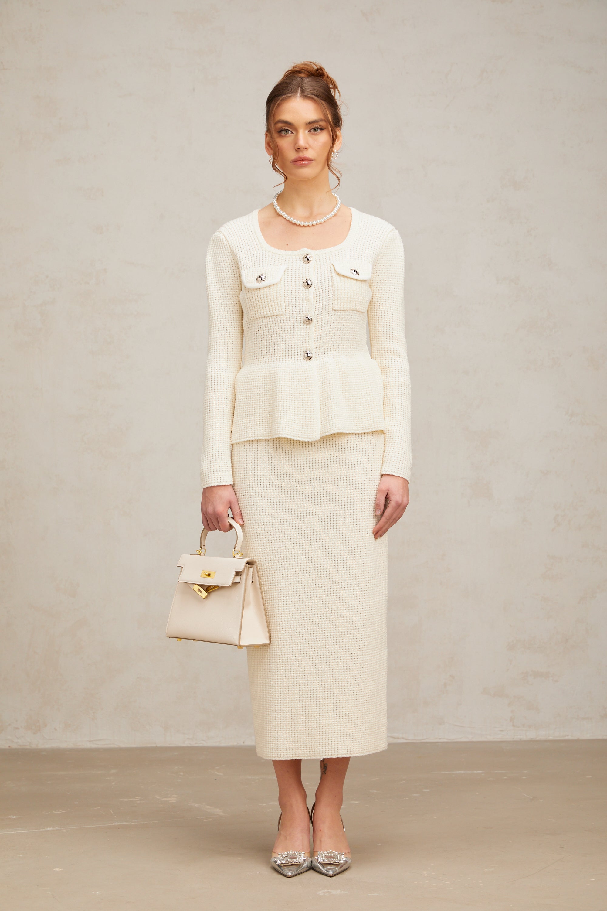 Passendes Set aus weißem Strickoberteil und -rock von Manon