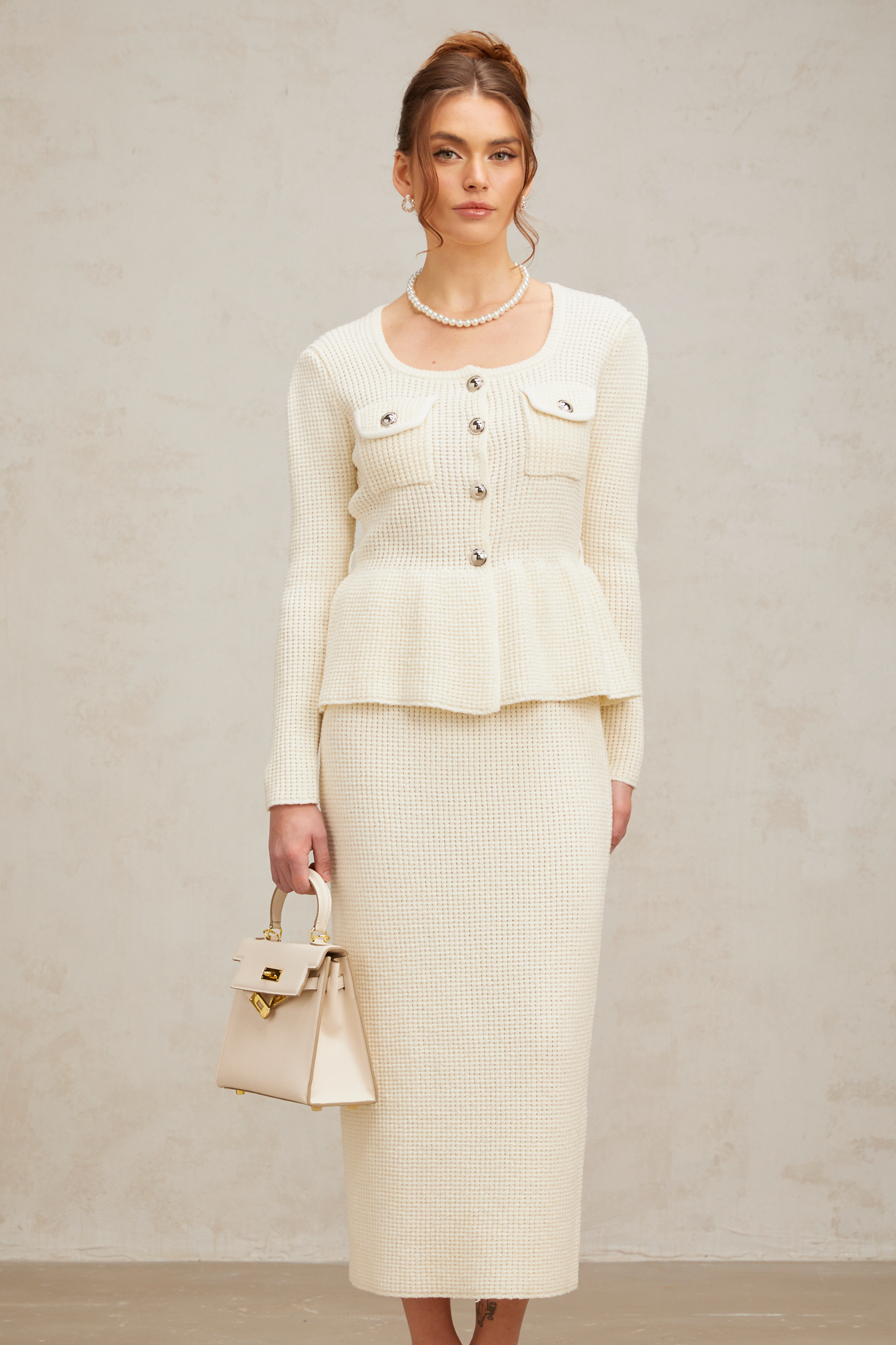 Passendes Set aus weißem Strickoberteil und -rock von Manon