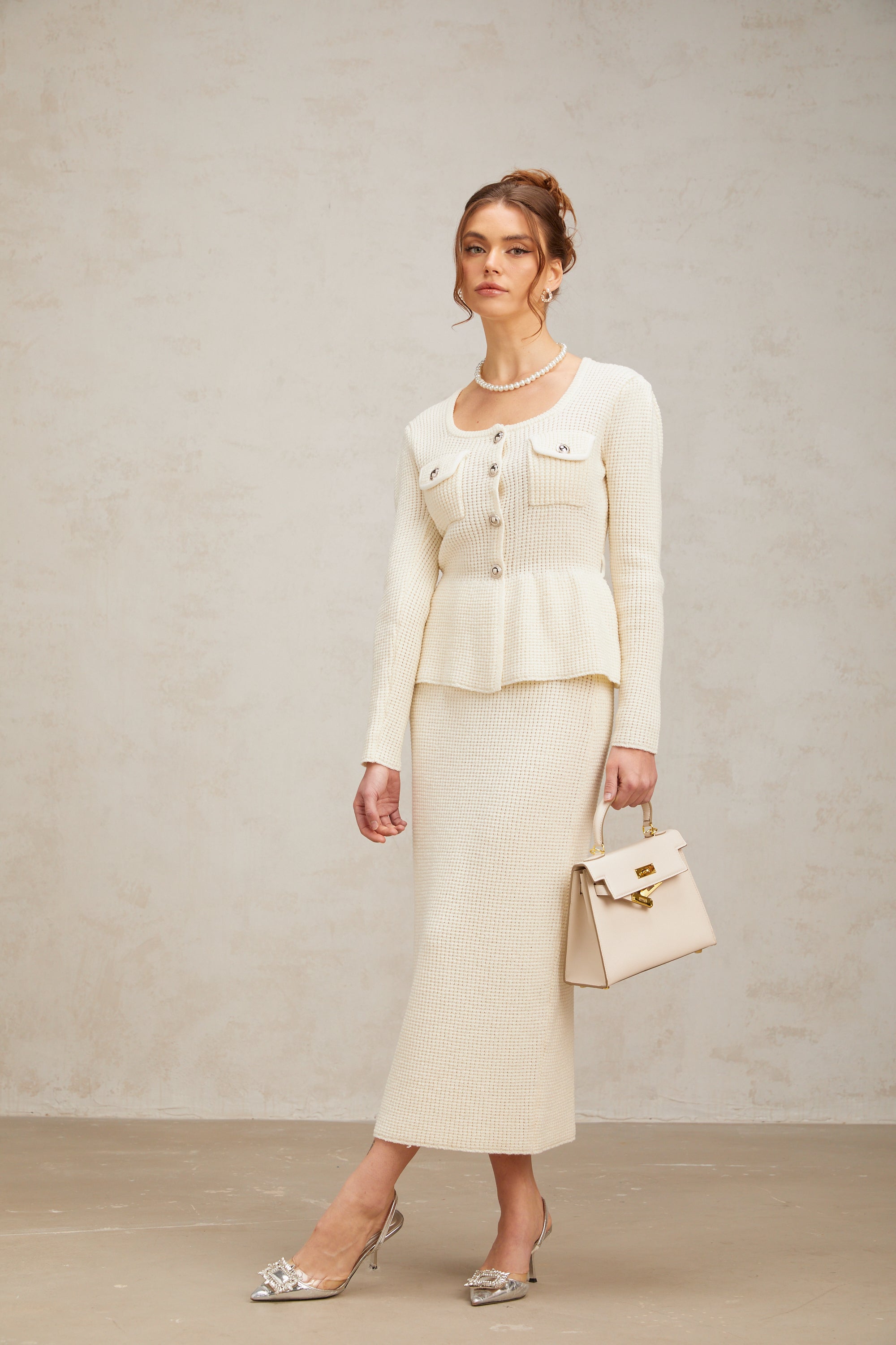 Passendes Set aus weißem Strickoberteil und -rock von Manon