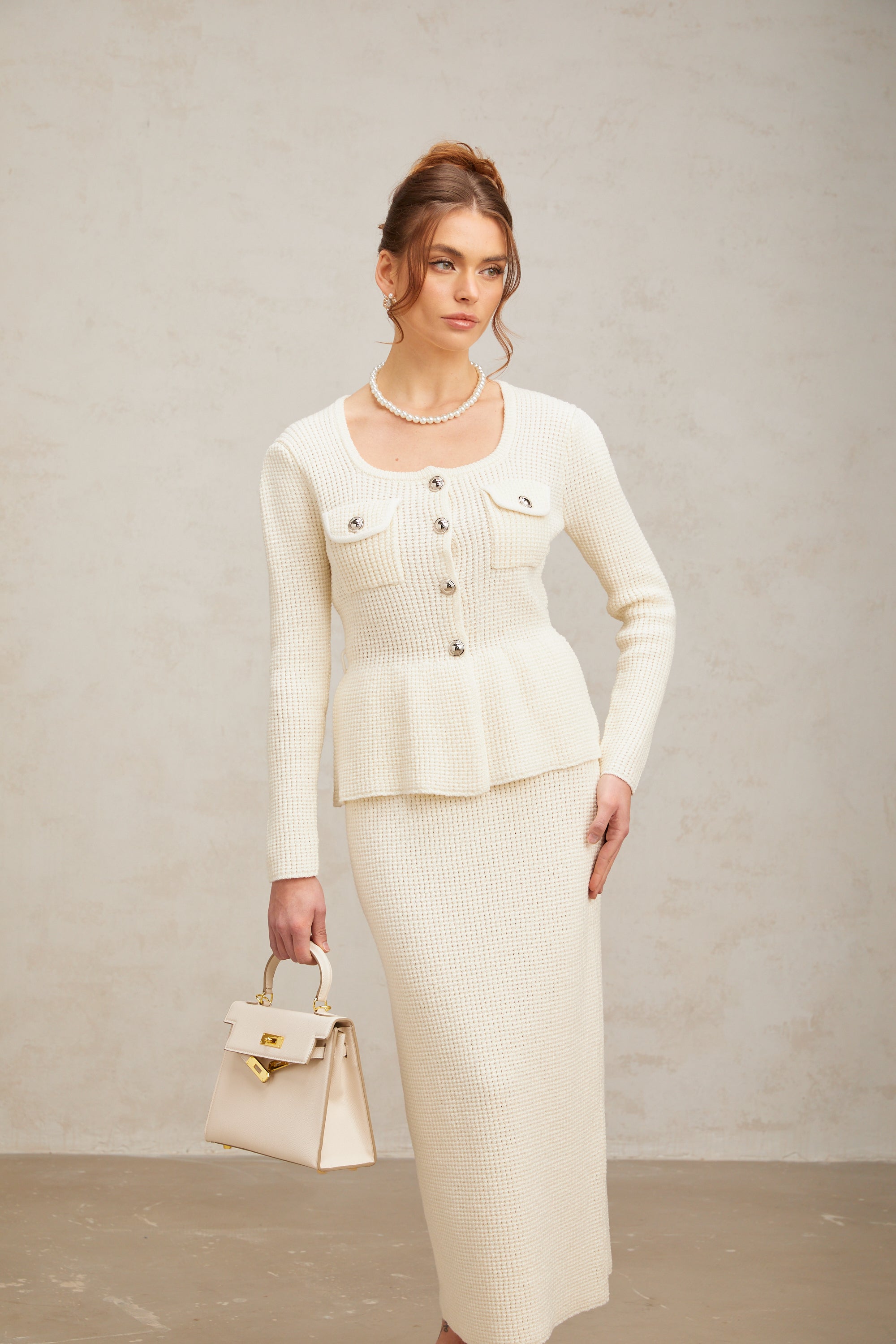 Passendes Set aus weißem Strickoberteil und -rock von Manon