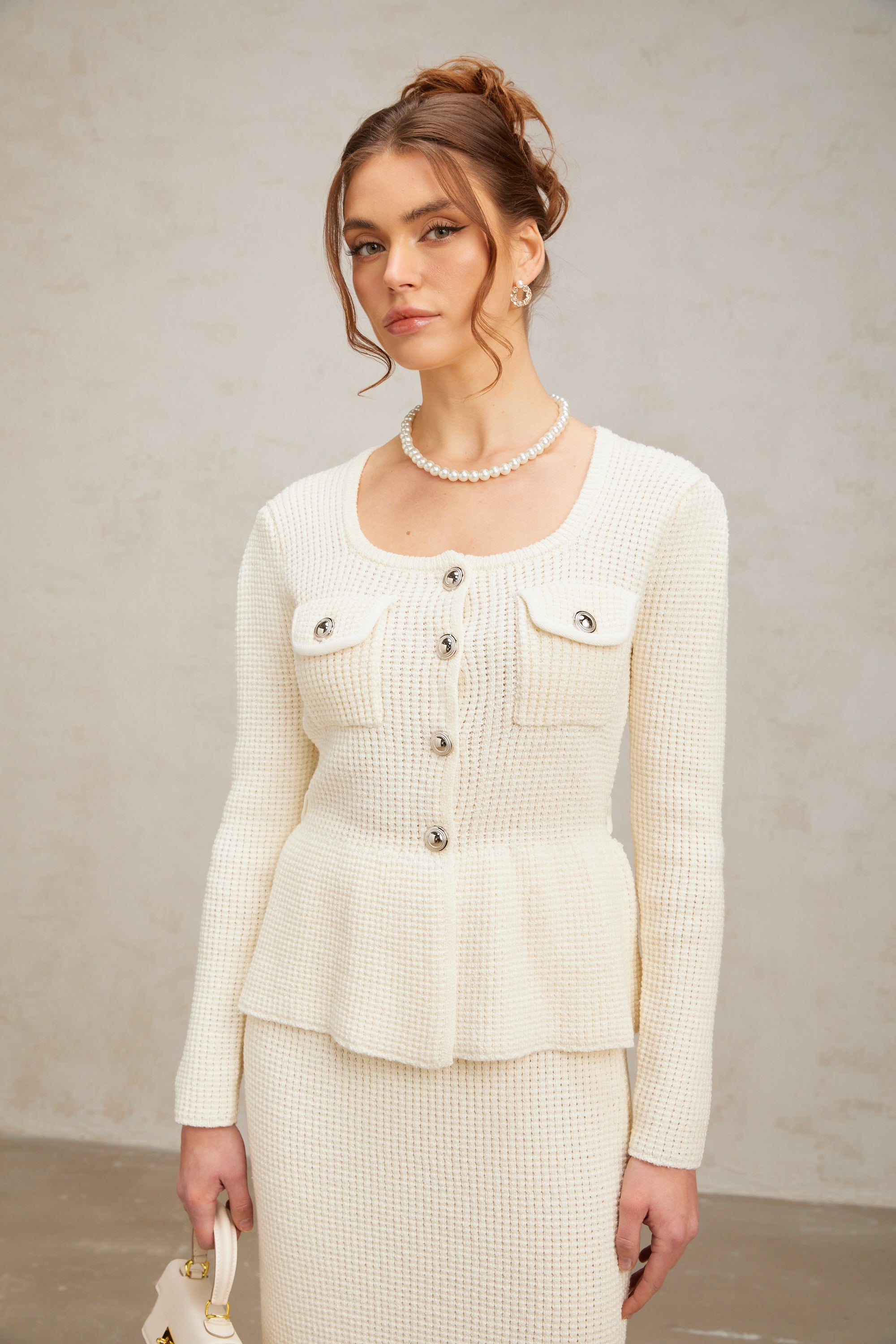 Passendes Set aus weißem Strickoberteil und -rock von Manon