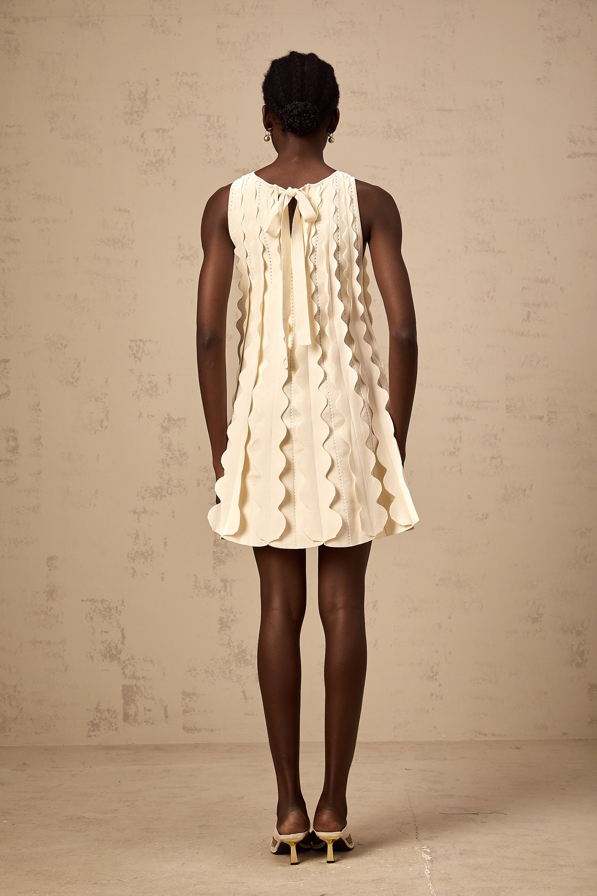 فستان Axelle الأبيض القصير بدون أكمام بتفاصيل متموجة