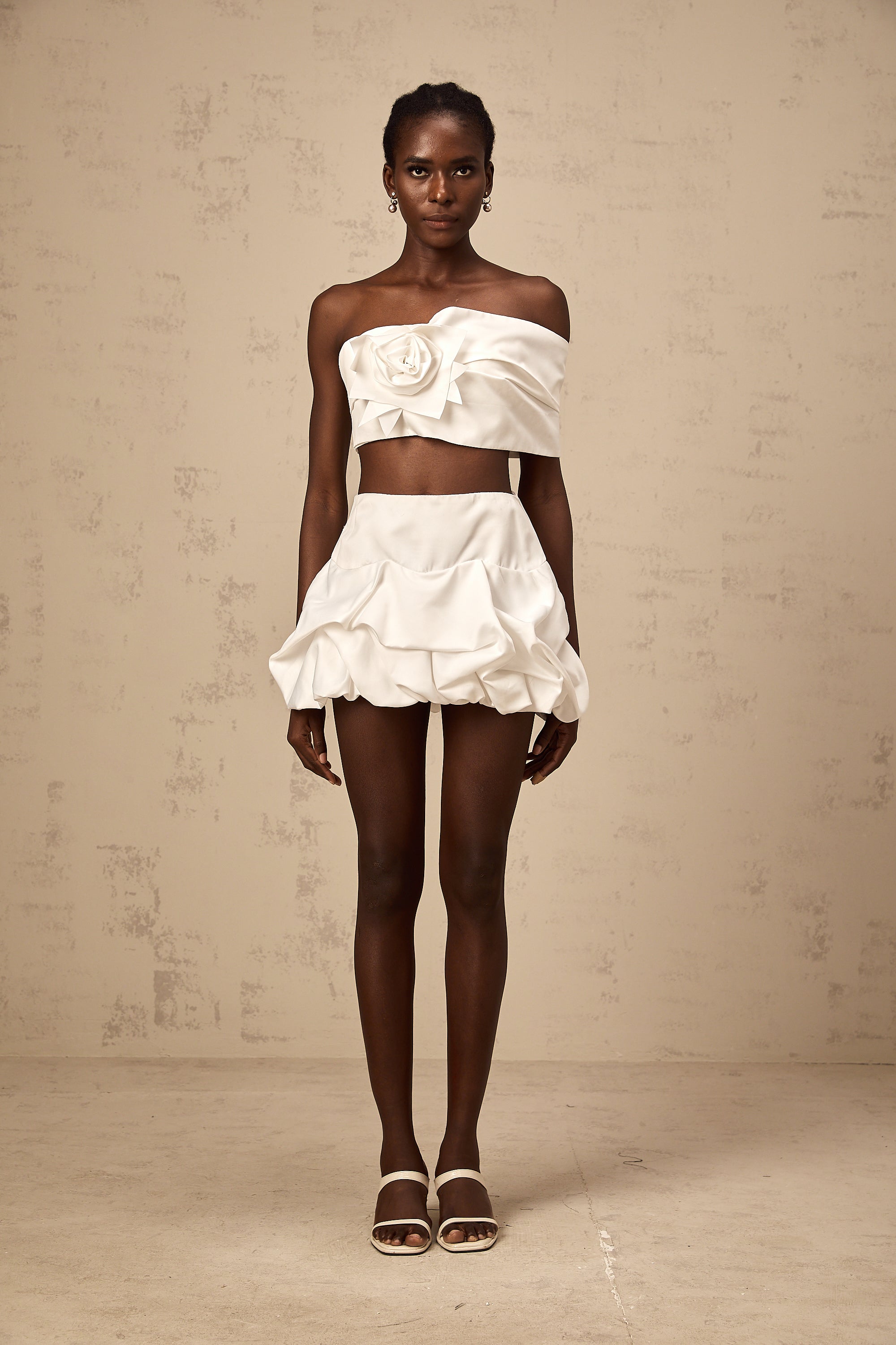 طقم هونورين المكون من بلوزة وتنورة مزينة بثنيات زهرية باللون الأبيض