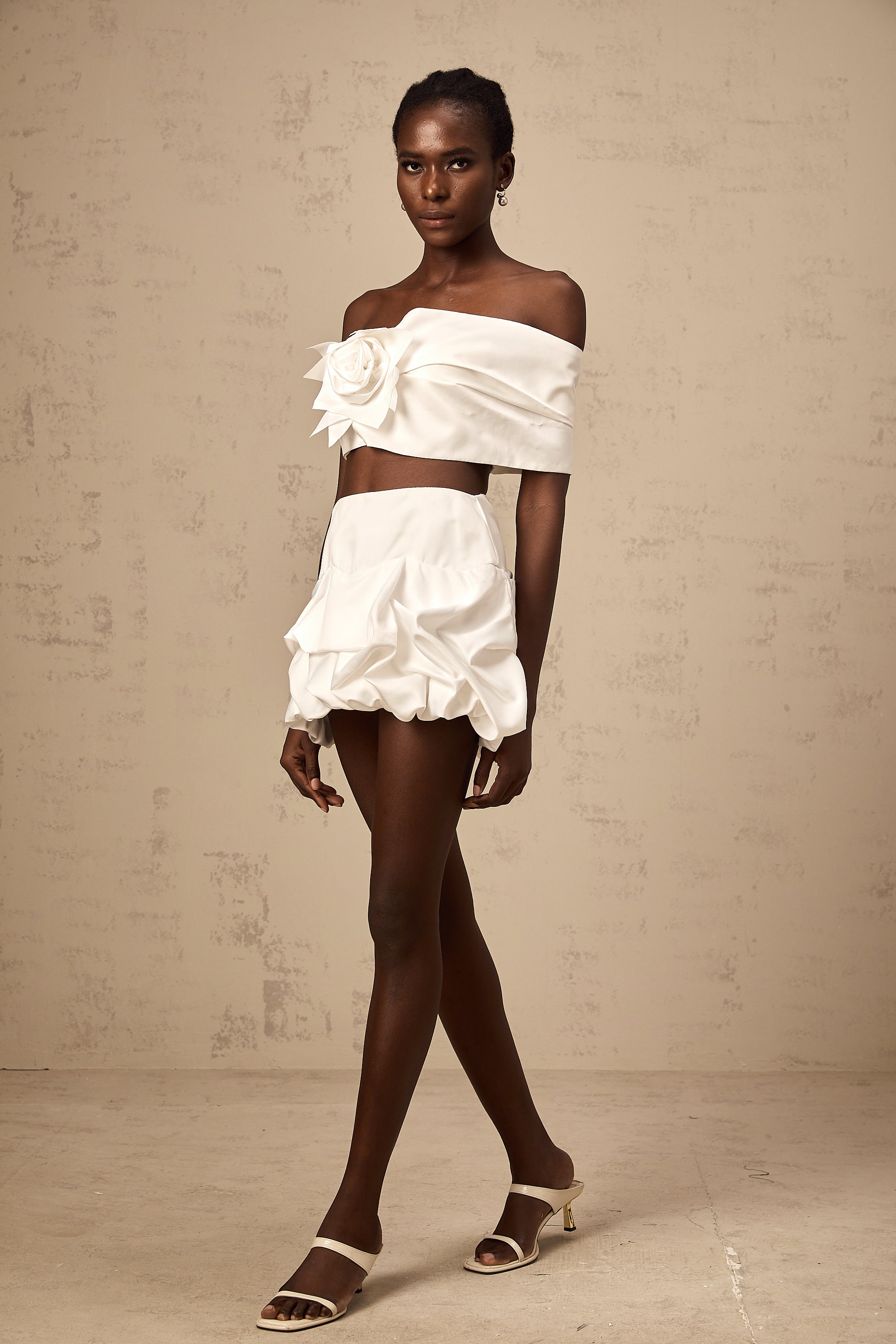 طقم هونورين المكون من بلوزة وتنورة مزينة بثنيات زهرية باللون الأبيض