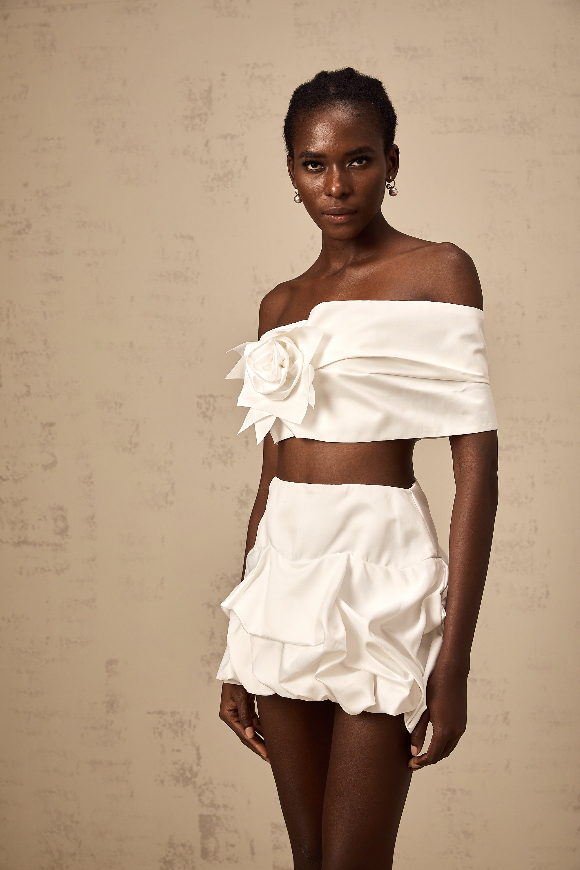 طقم هونورين المكون من بلوزة وتنورة مزينة بثنيات زهرية باللون الأبيض