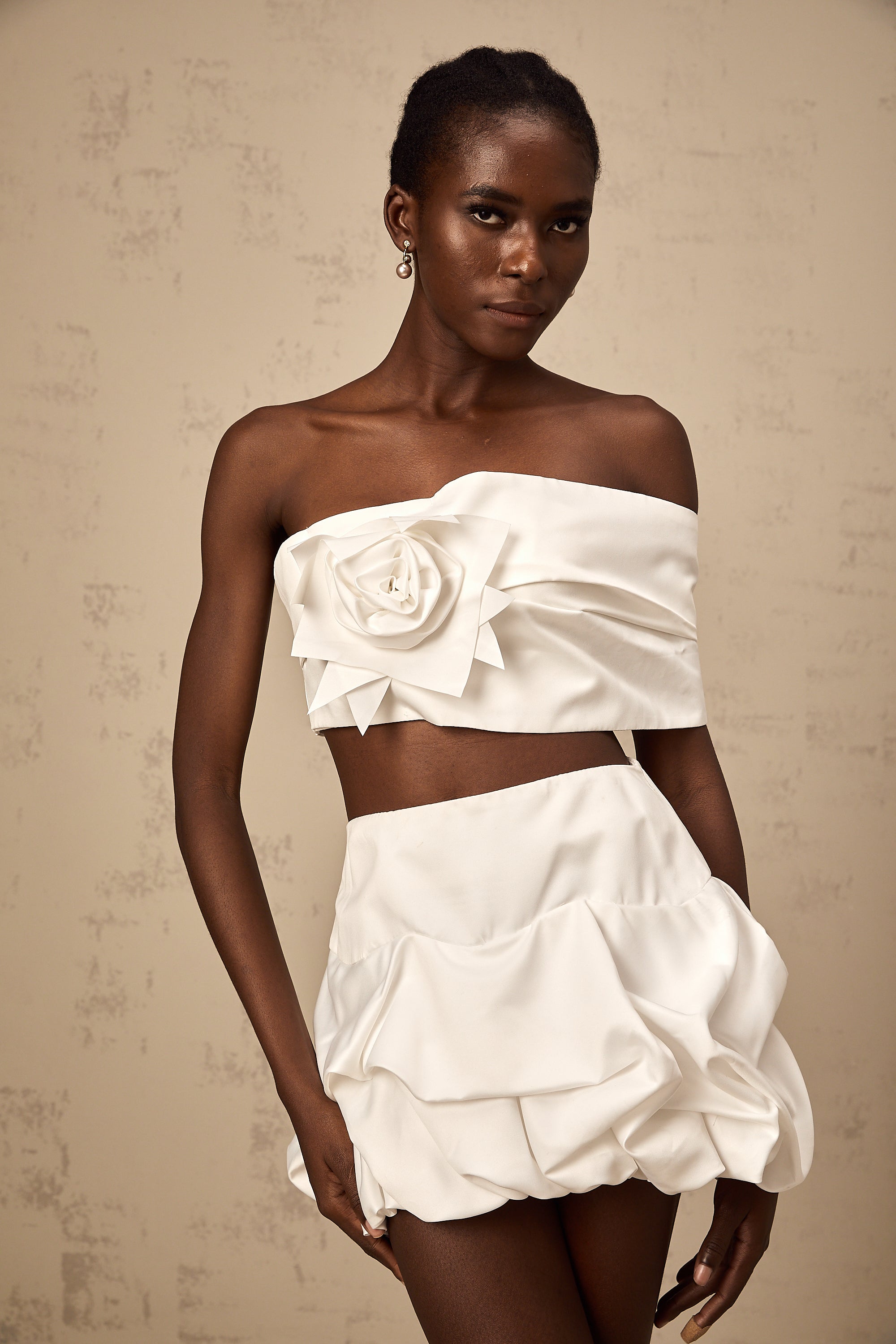 طقم هونورين المكون من بلوزة وتنورة مزينة بثنيات زهرية باللون الأبيض