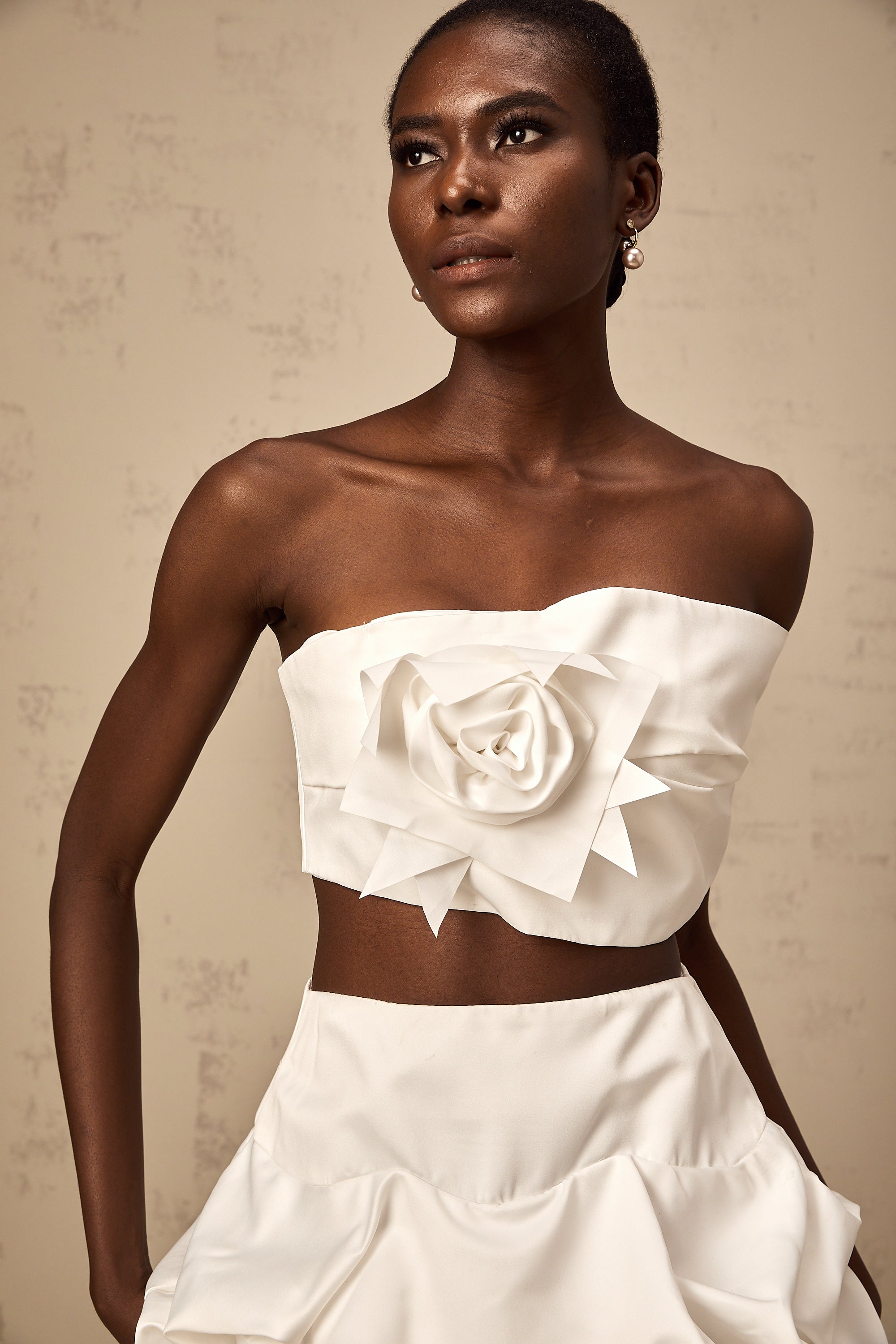 طقم هونورين المكون من بلوزة وتنورة مزينة بثنيات زهرية باللون الأبيض