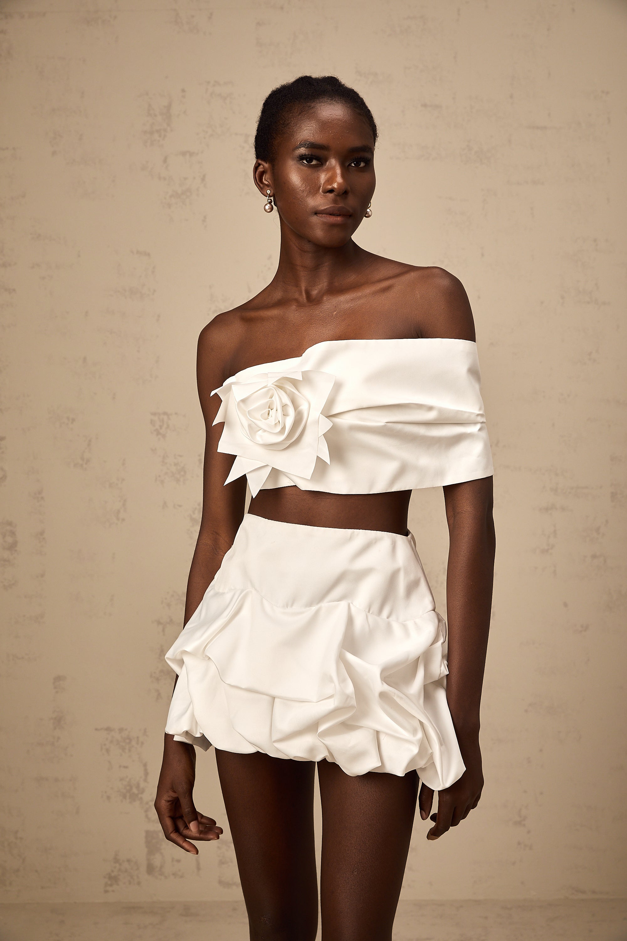 طقم هونورين المكون من بلوزة وتنورة مزينة بثنيات زهرية باللون الأبيض