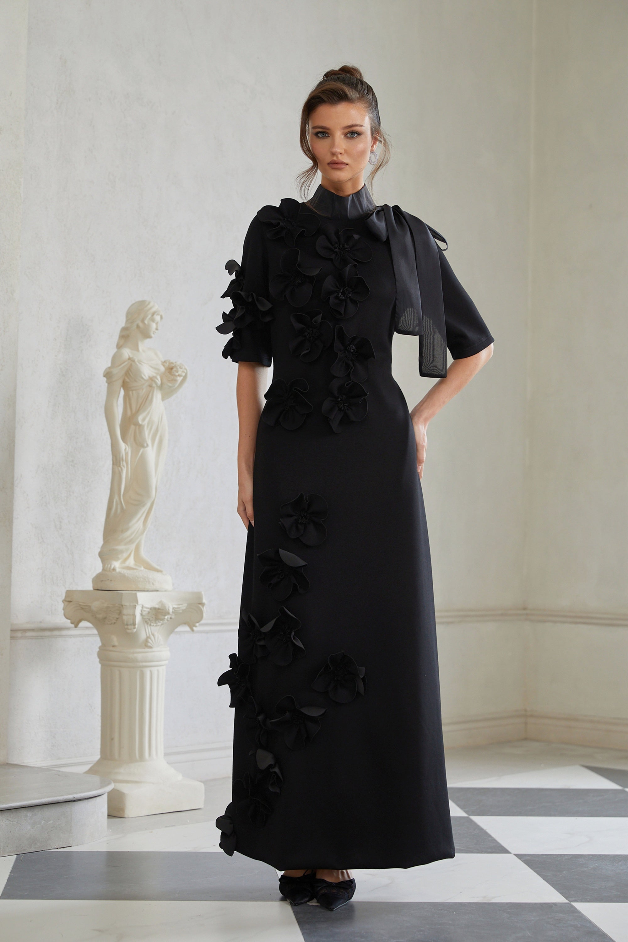 Isidora Schwarzes Maxikleid mit Schleife und Blumenapplikationen