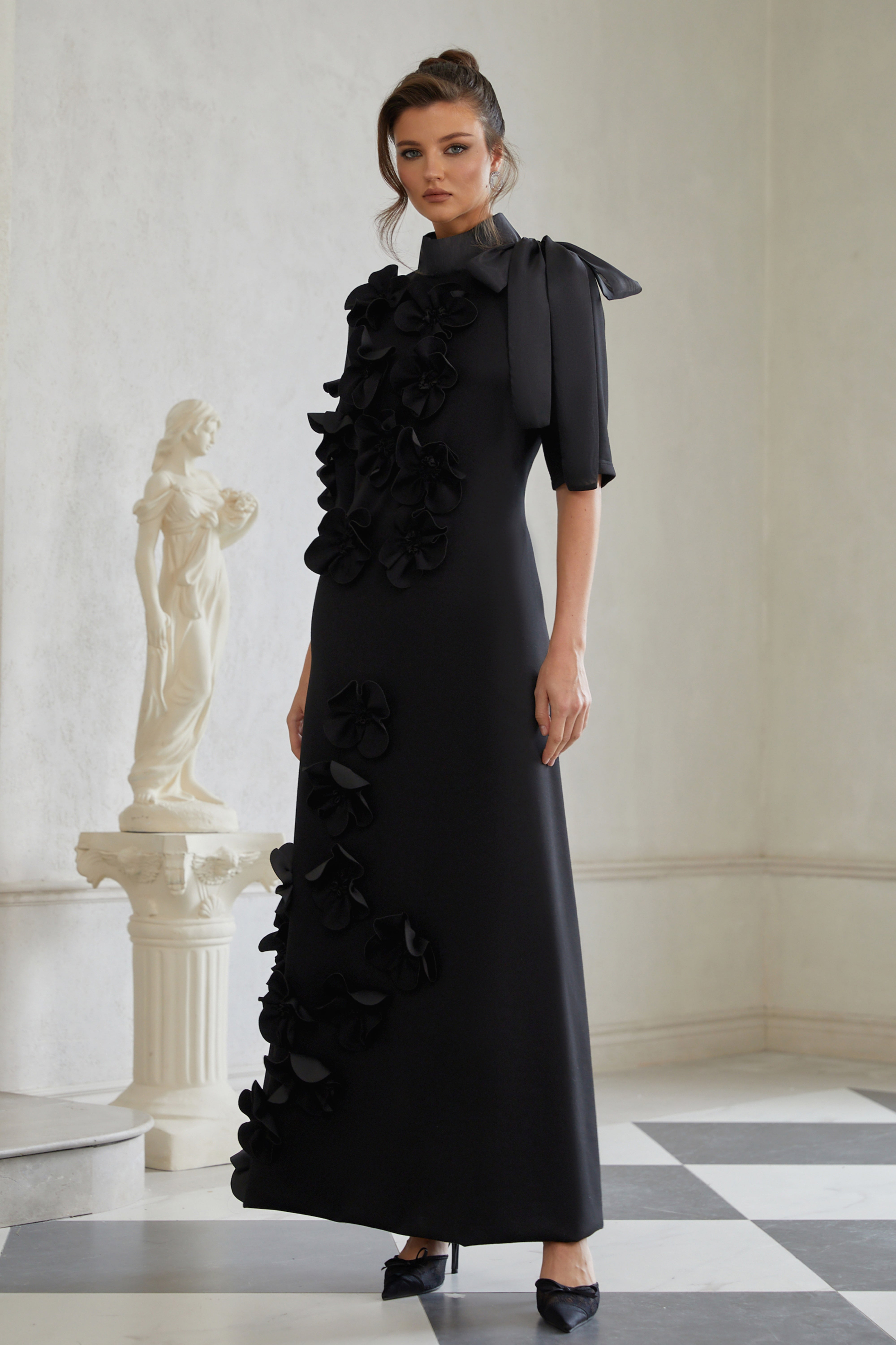 Isidora Schwarzes Maxikleid mit Schleife und Blumenapplikationen