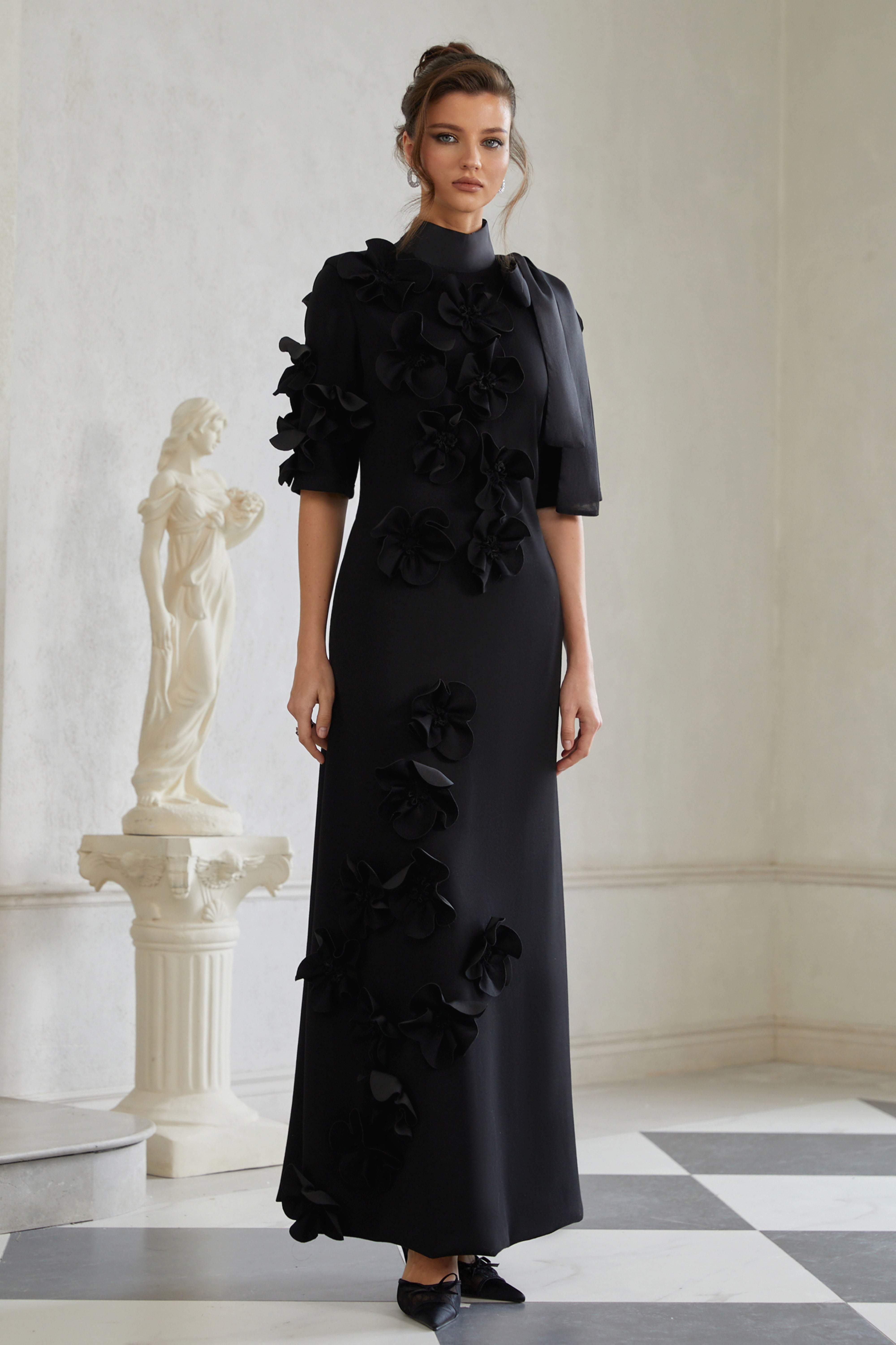 Isidora Schwarzes Maxikleid mit Schleife und Blumenapplikationen