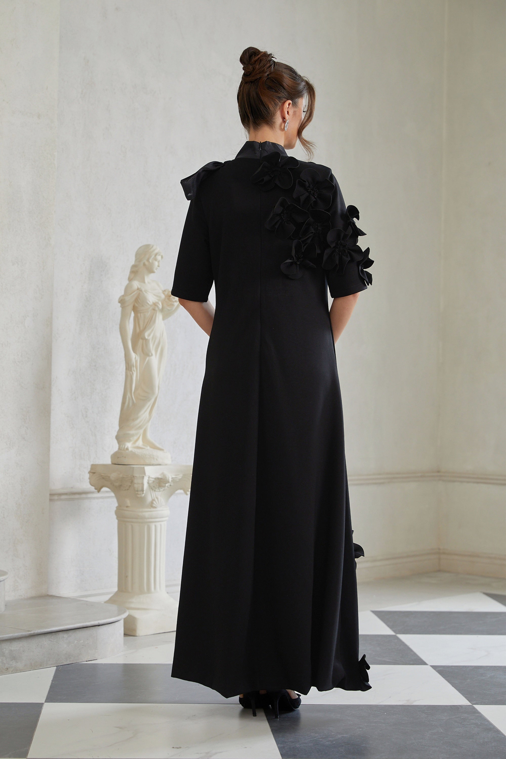 Isidora Schwarzes Maxikleid mit Schleife und Blumenapplikationen