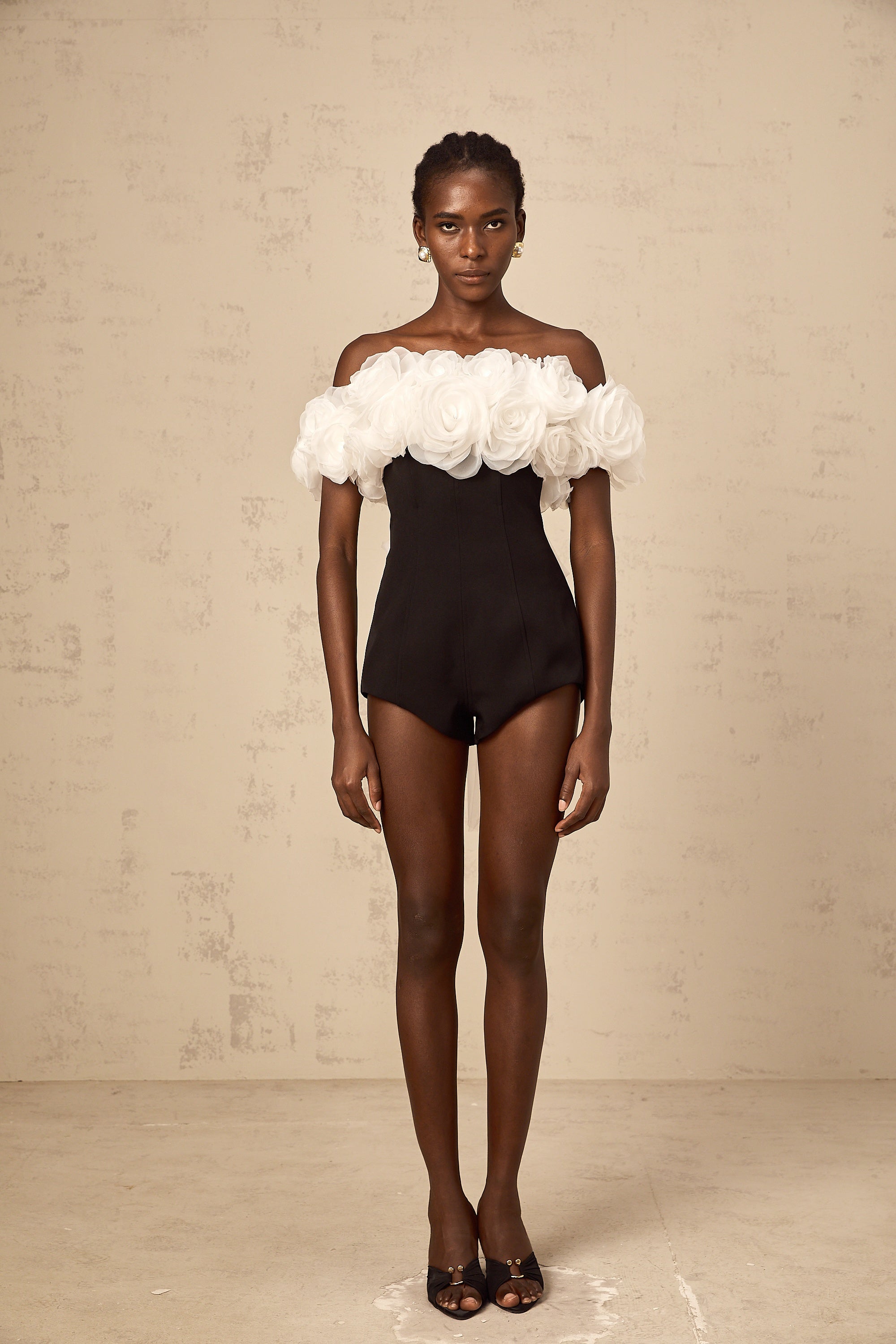 Yseut – Schwarzer, schulterfreier Playsuit mit 3D-Blütenblättern