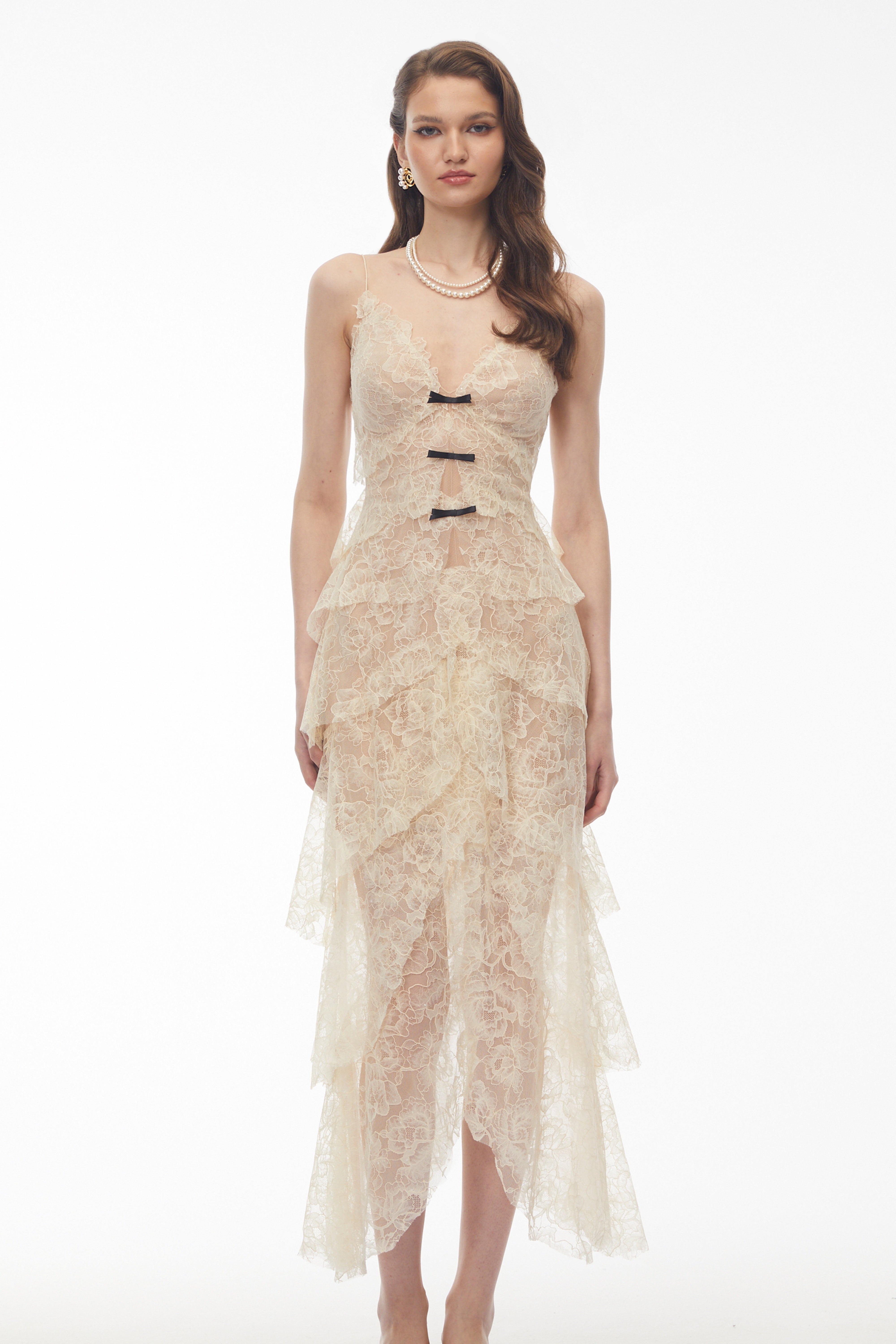 Robe longue à volants en dentelle couleur crème, rehaussée de petits nœuds noirs