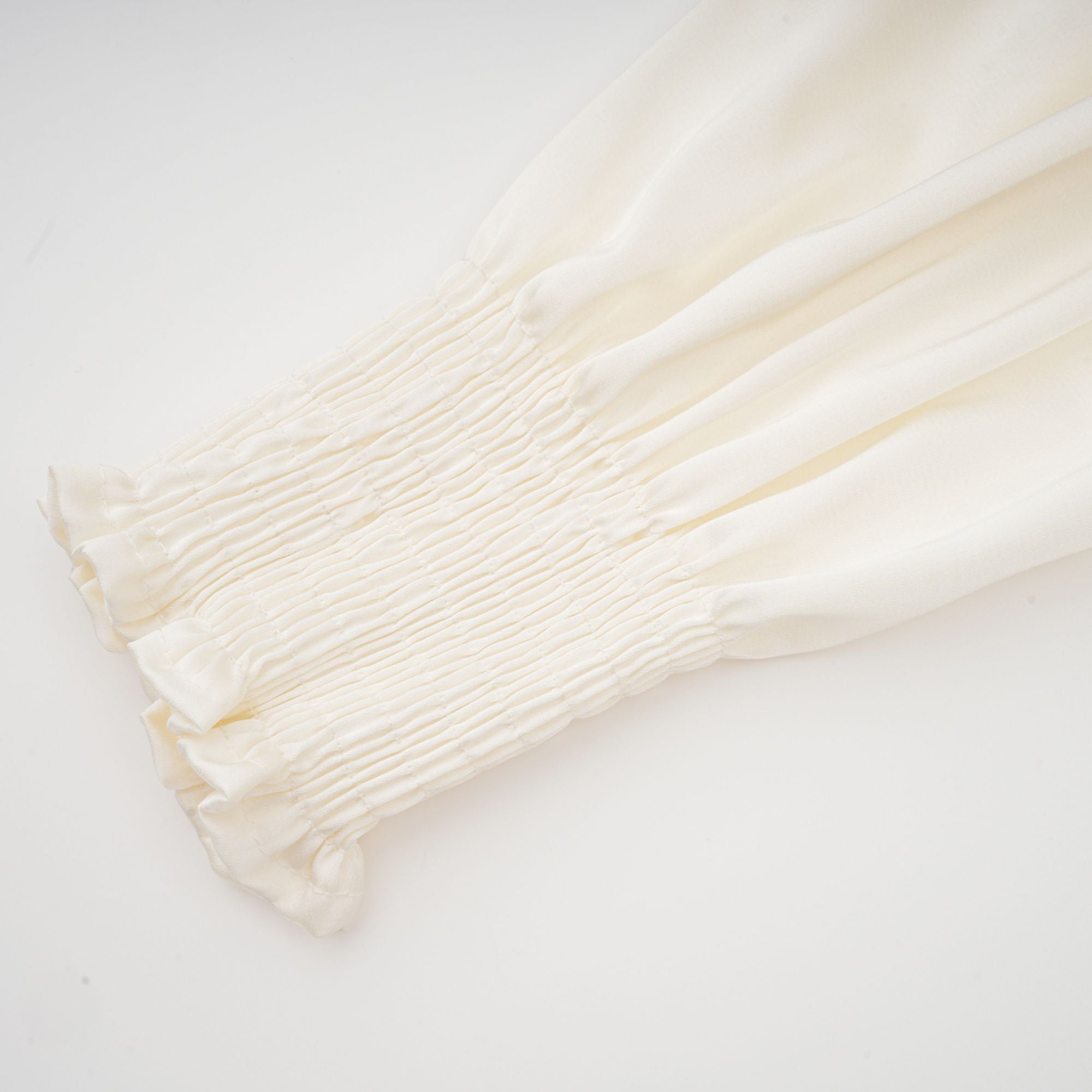 بلوزة نوريا البيضاء المقصوصة بنقشة زهور صناعية