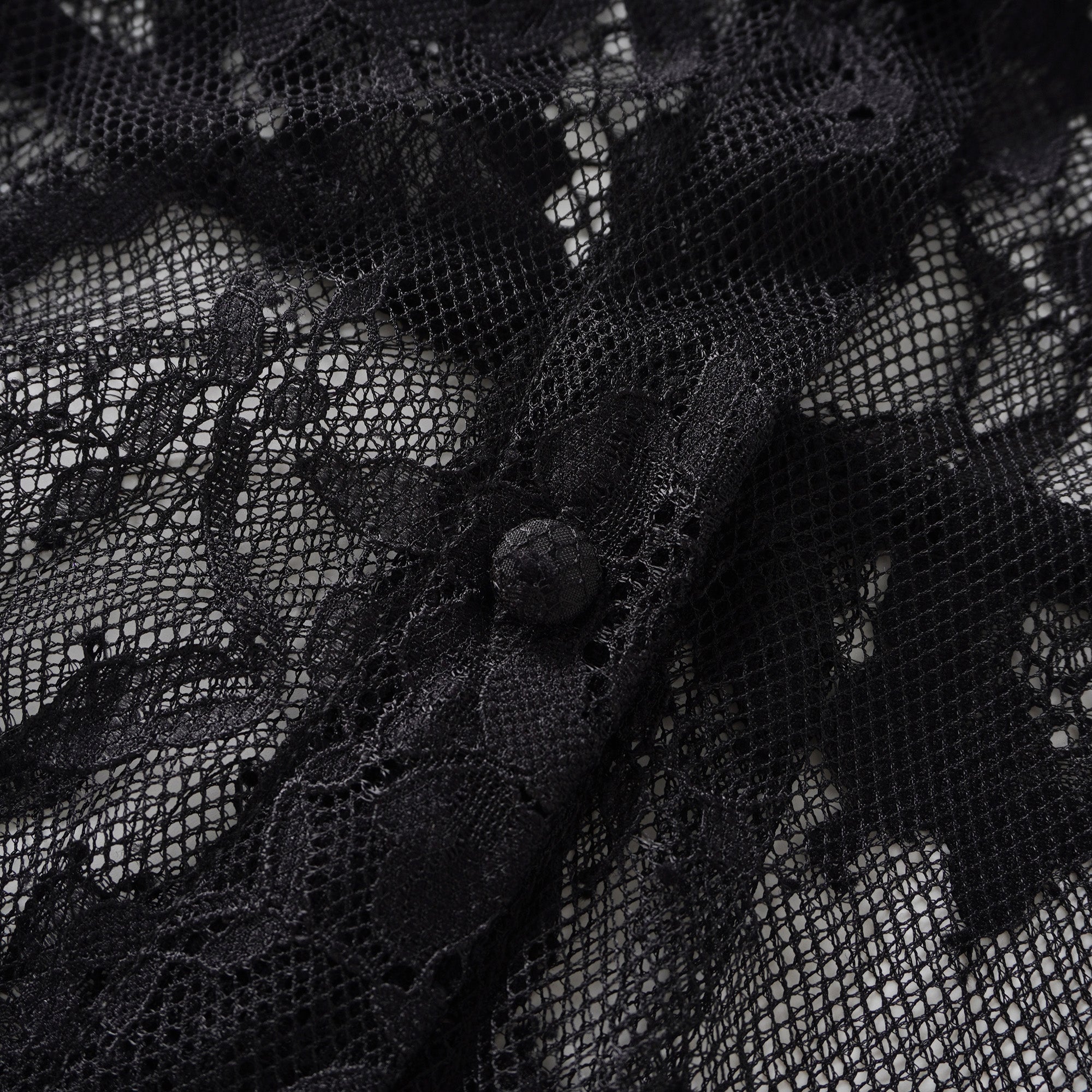 بلوزة كوينتين ذات الرقبة المزينة بشريط أسود من الدانتيل المزخرف.