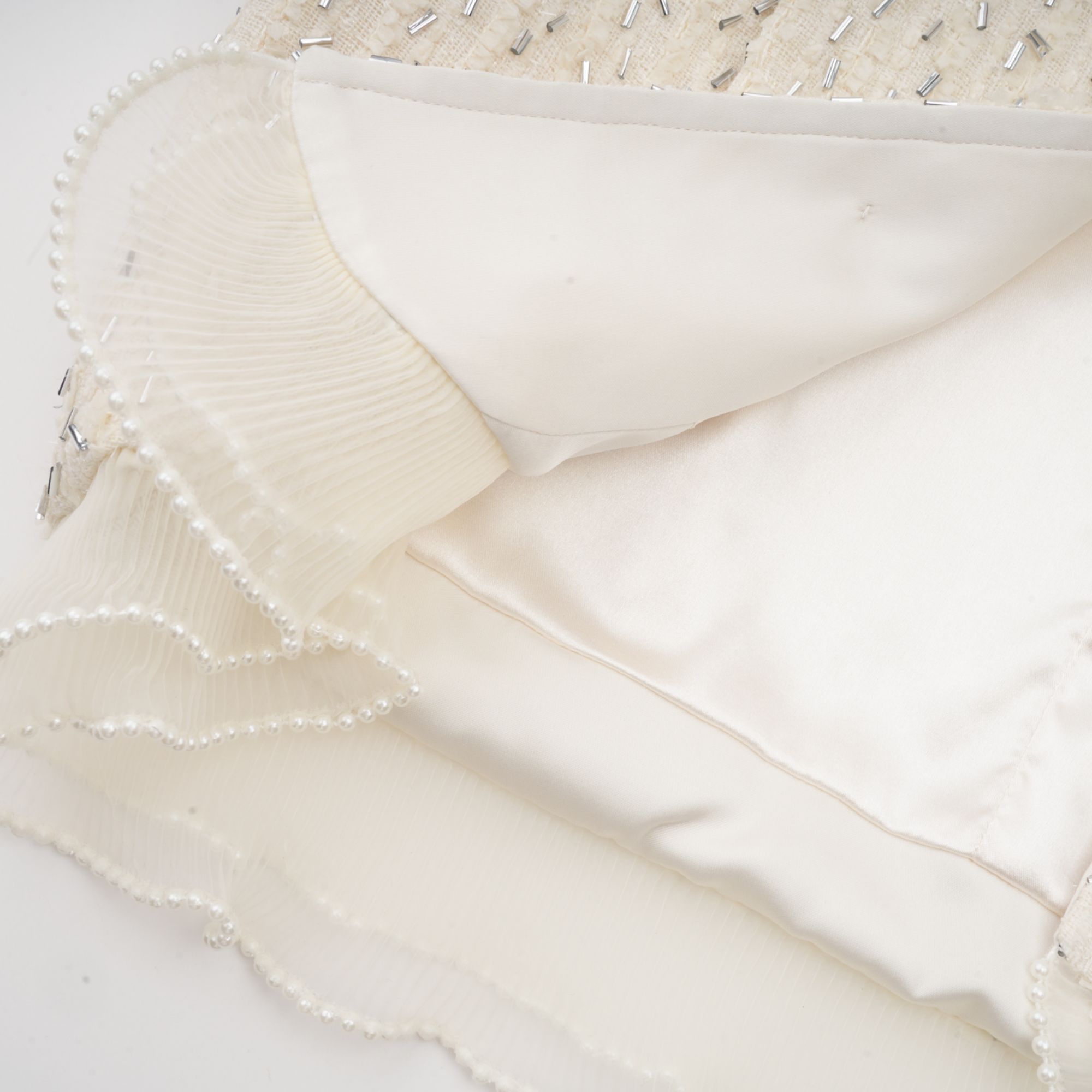 سترة بلانش البيضاء المقصوصة والمزينة بالكشكشة