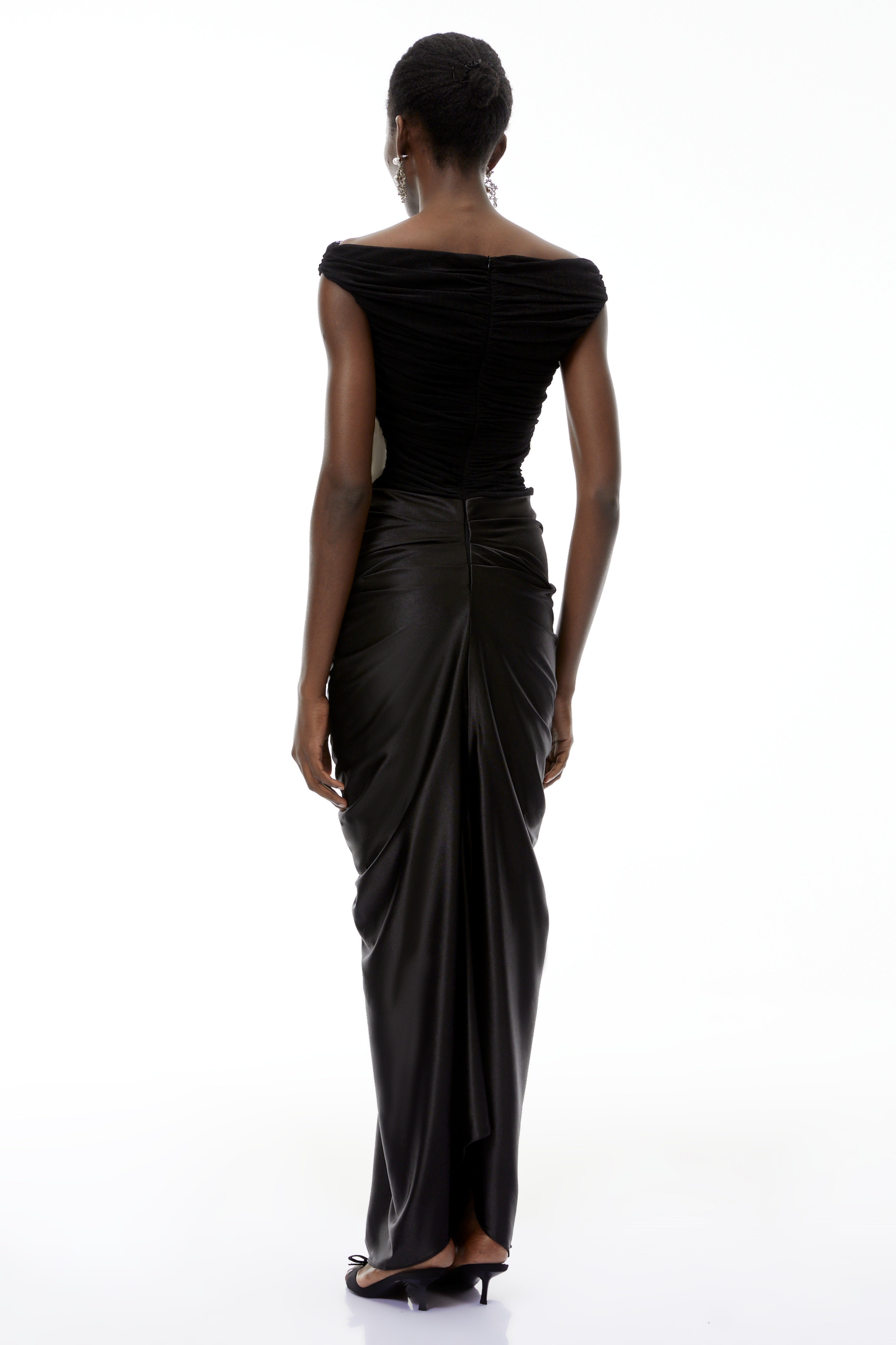 فستان طويل من إيدن باللون الأسود، مكشوف الكتفين ومزين بكشكشة