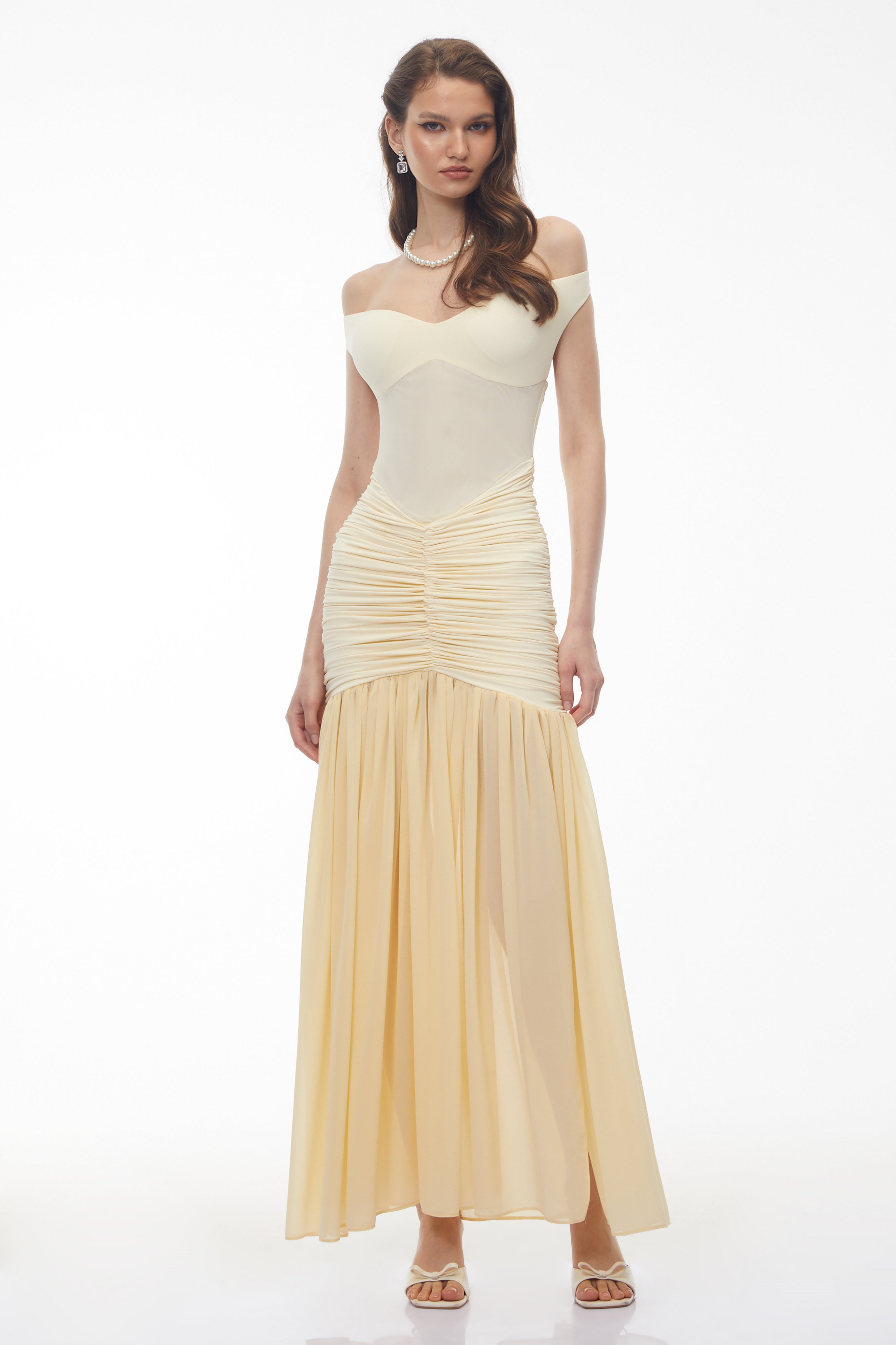 فستان ماكسي أصفر مكشوف الكتفين ومزين بكشكشة