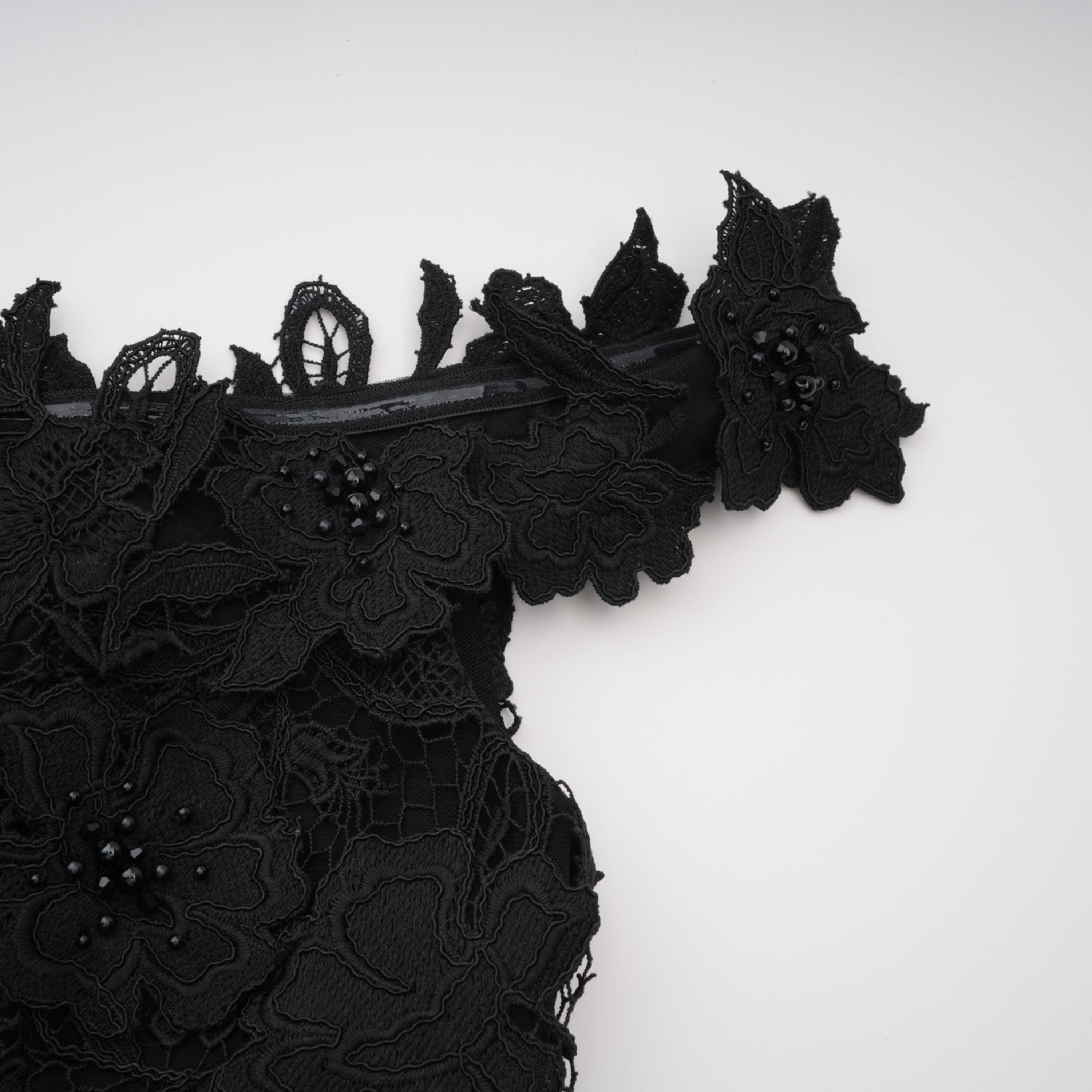 فستان طويل من الدانتيل المطرز باللون الأسود من ماركة «هيكاتي» مع زخارف زهور ثلاثية الأبعاد