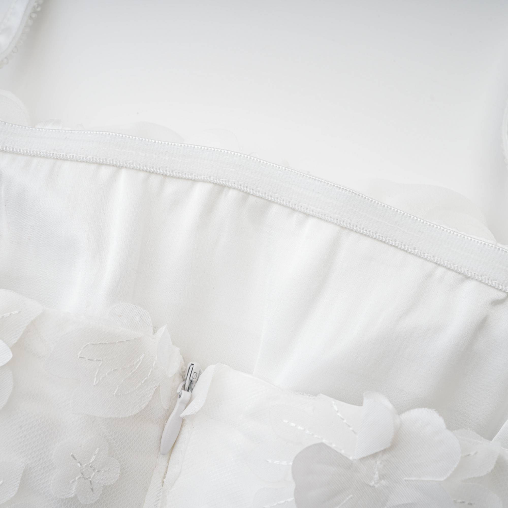 فستان Apolline قصير باللون الأبيض مع زهور صناعية