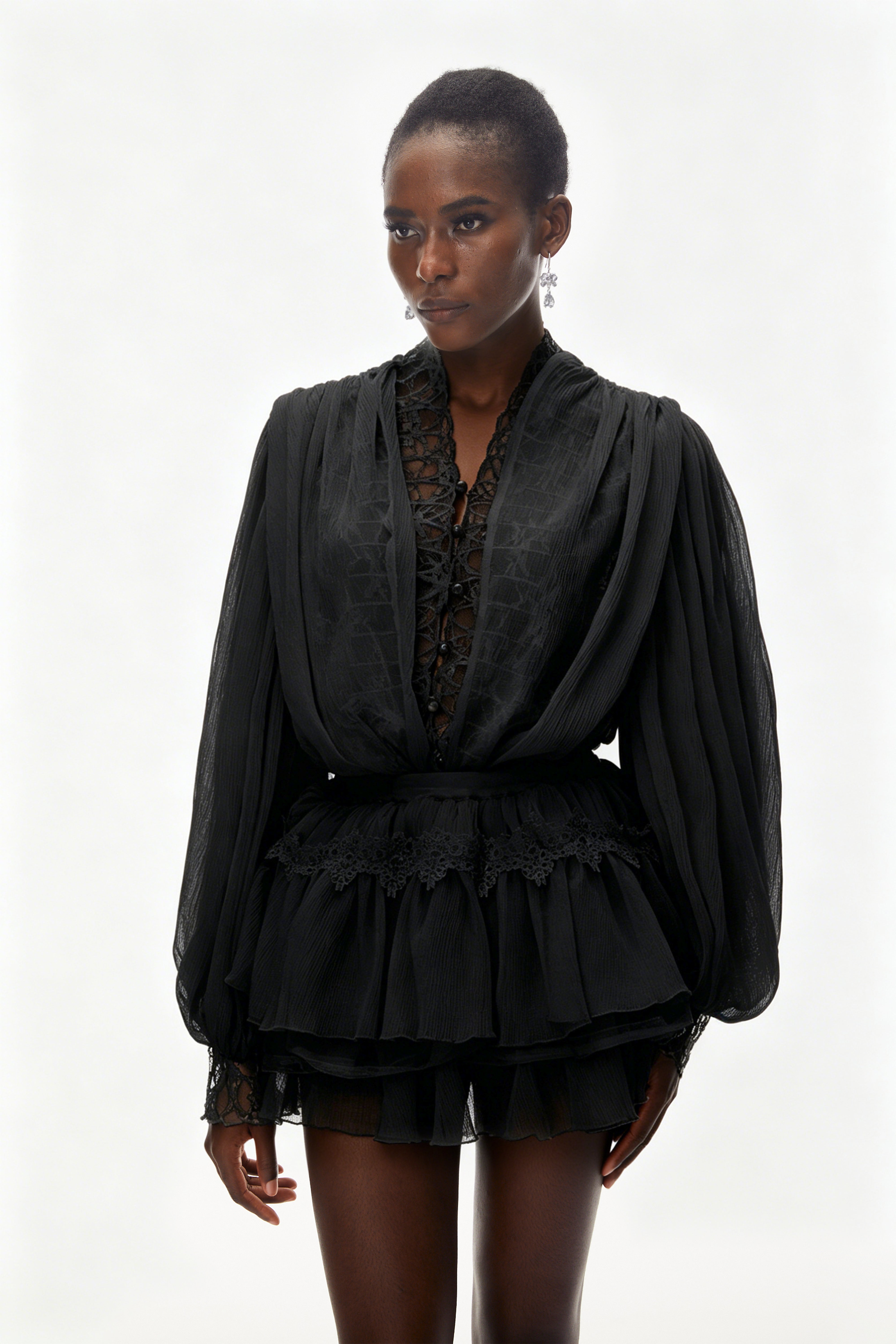 Ensemble composé d'un chemisier noir à bordures en dentelle et d'une jupe à volants