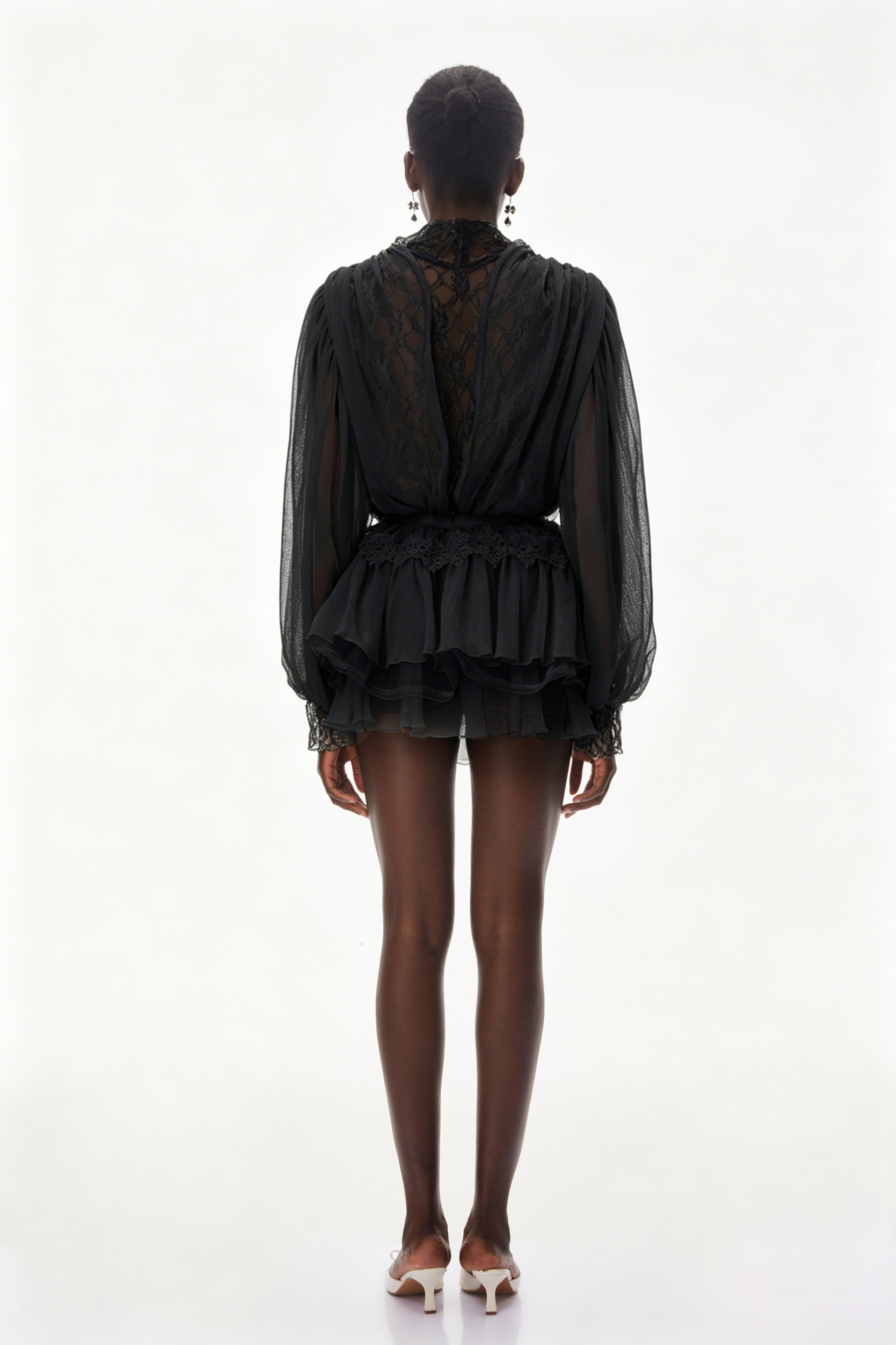 Ensemble composé d'un chemisier noir à bordures en dentelle et d'une jupe à volants