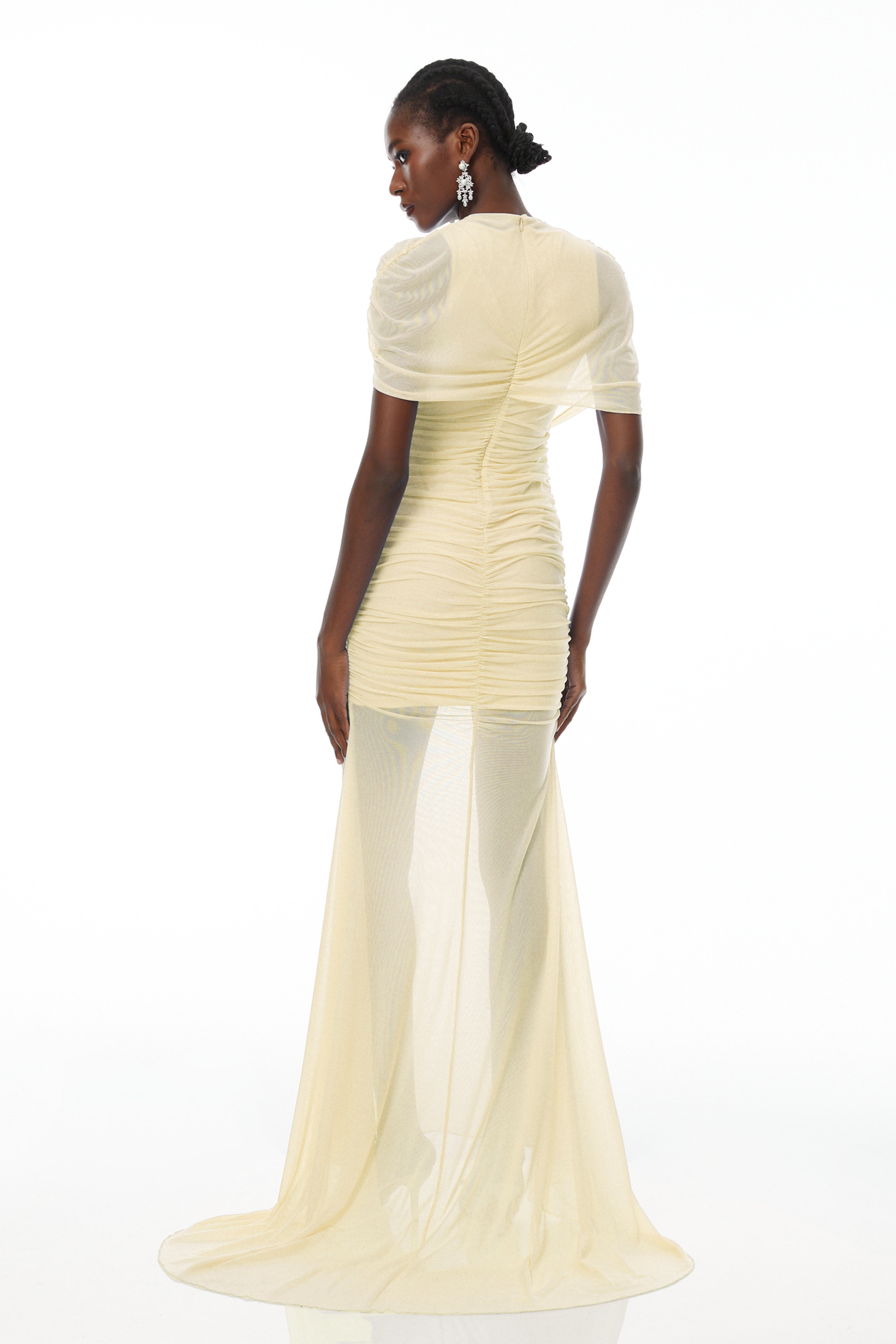 فستان طويل من شبكة "سيلفي" باللون الأصفر، بتصميم غير متماثل ومزين بكشكشة