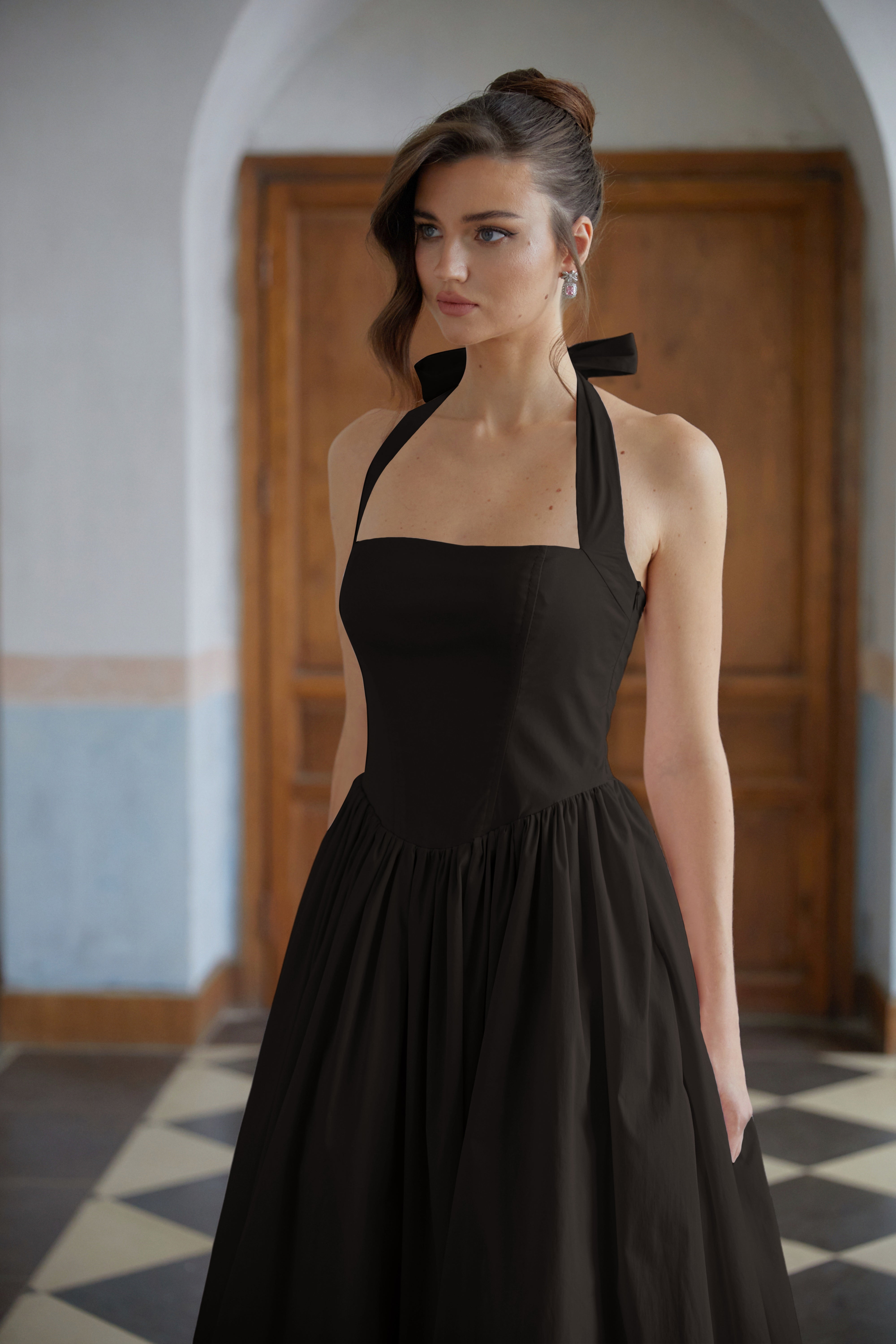 فستان ميدي أسود من إيبونين بتصميم طبقات وحاشية واسعة.