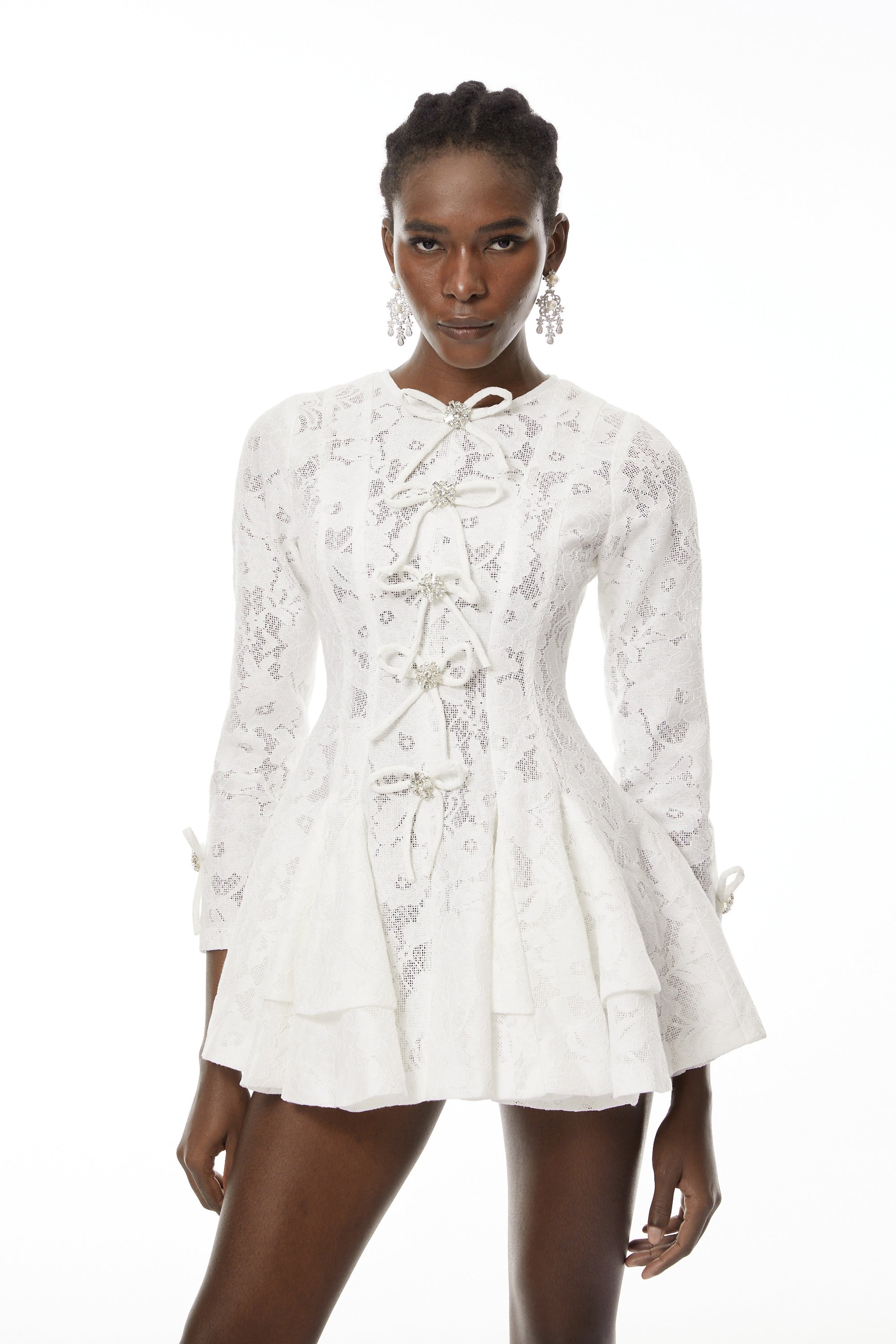 فستان قصير من الدانتيل الأبيض مع تفاصيل على شكل فيونكة من Céleste