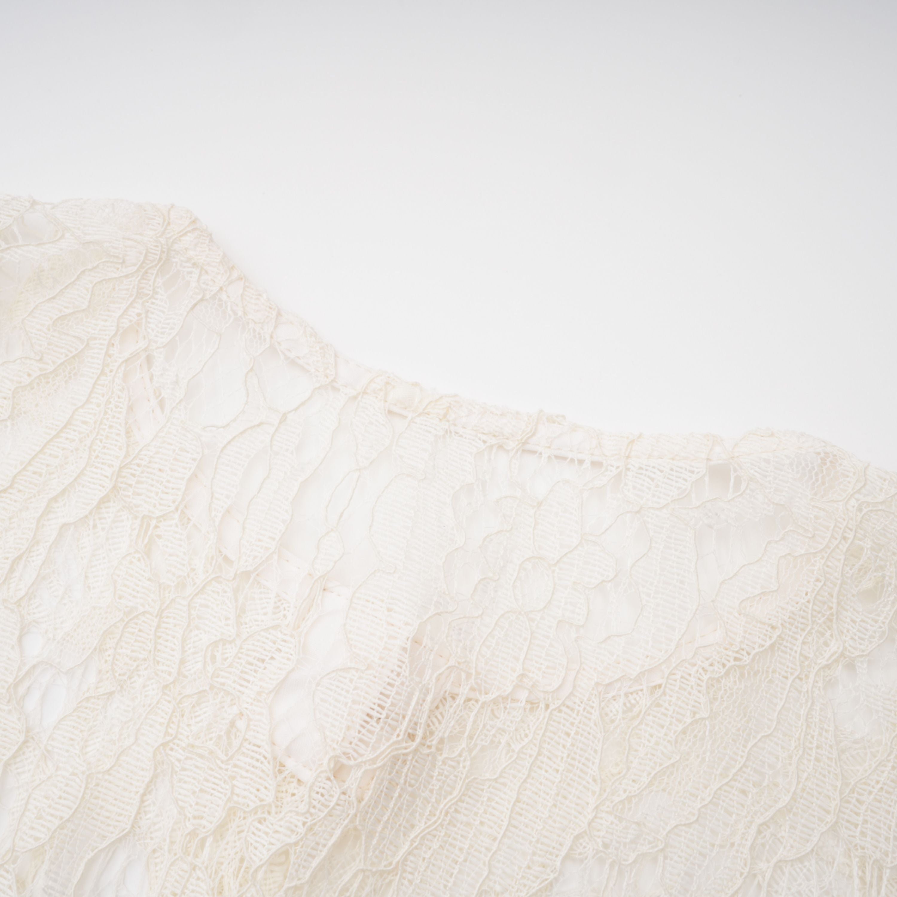 فستان ميدي أبيض من Alaia بتصميم رداء وطبعة زهور من الدانتيل