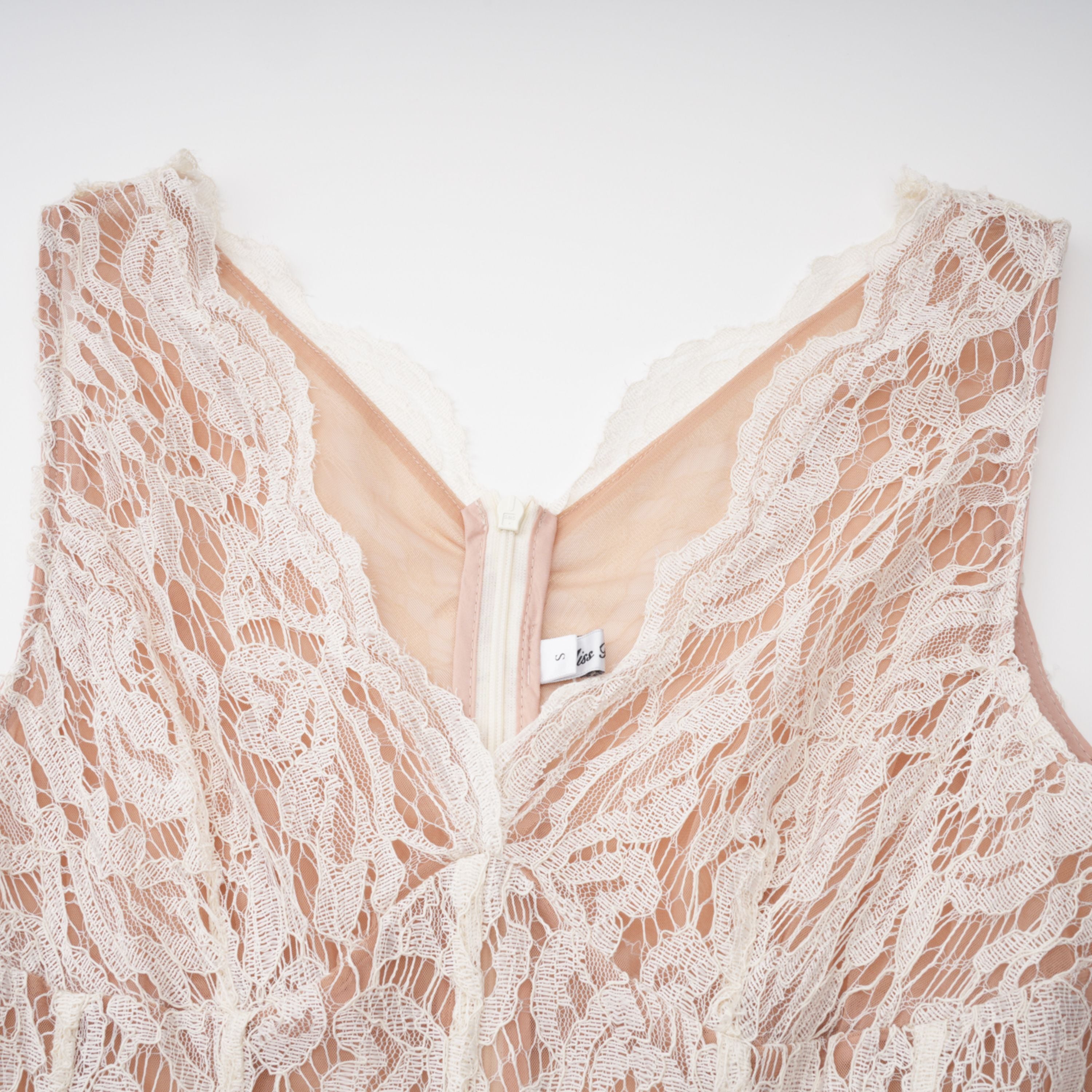 فستان ميدي أبيض من Alaia بتصميم رداء وطبعة زهور من الدانتيل