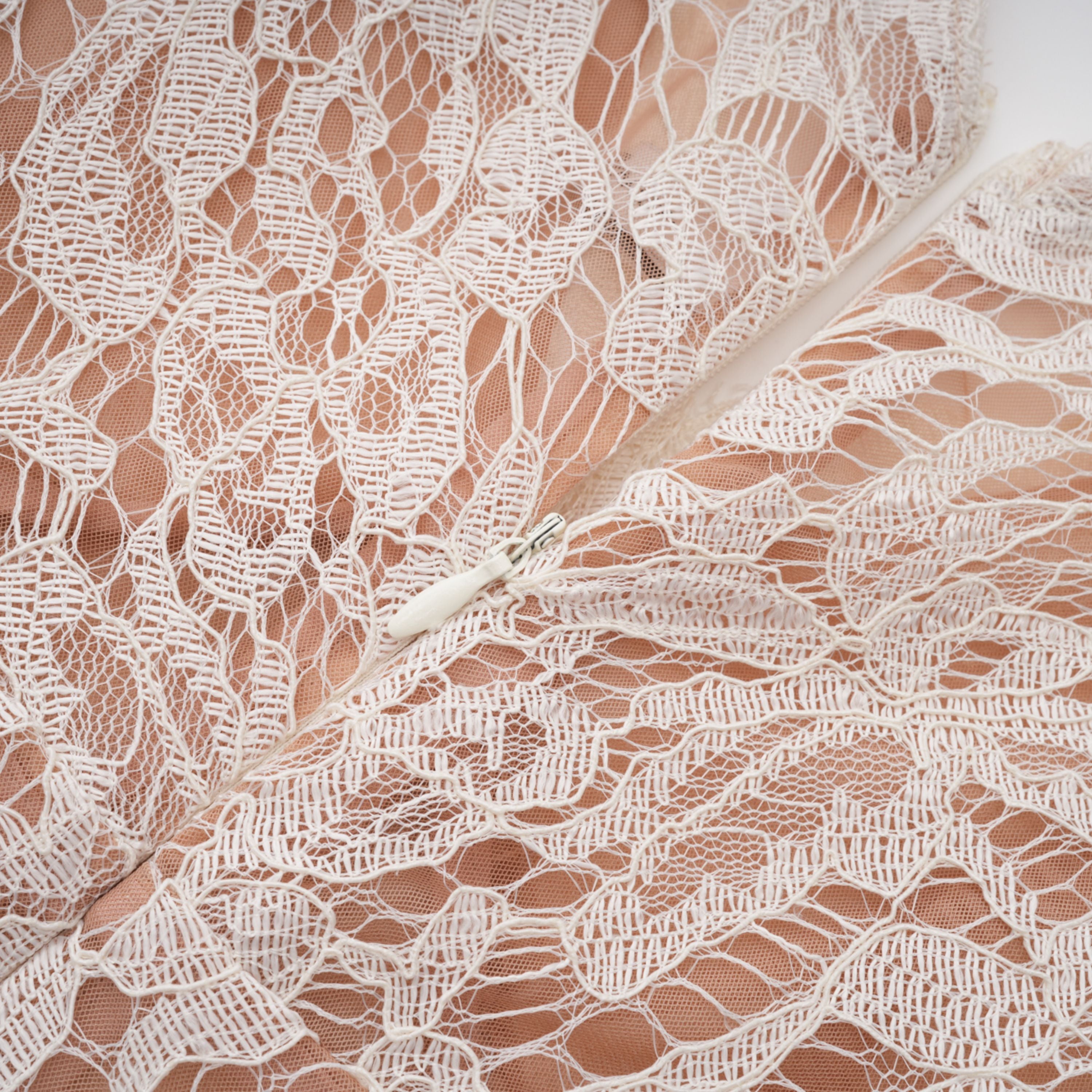 فستان ميدي أبيض من Alaia بتصميم رداء وطبعة زهور من الدانتيل