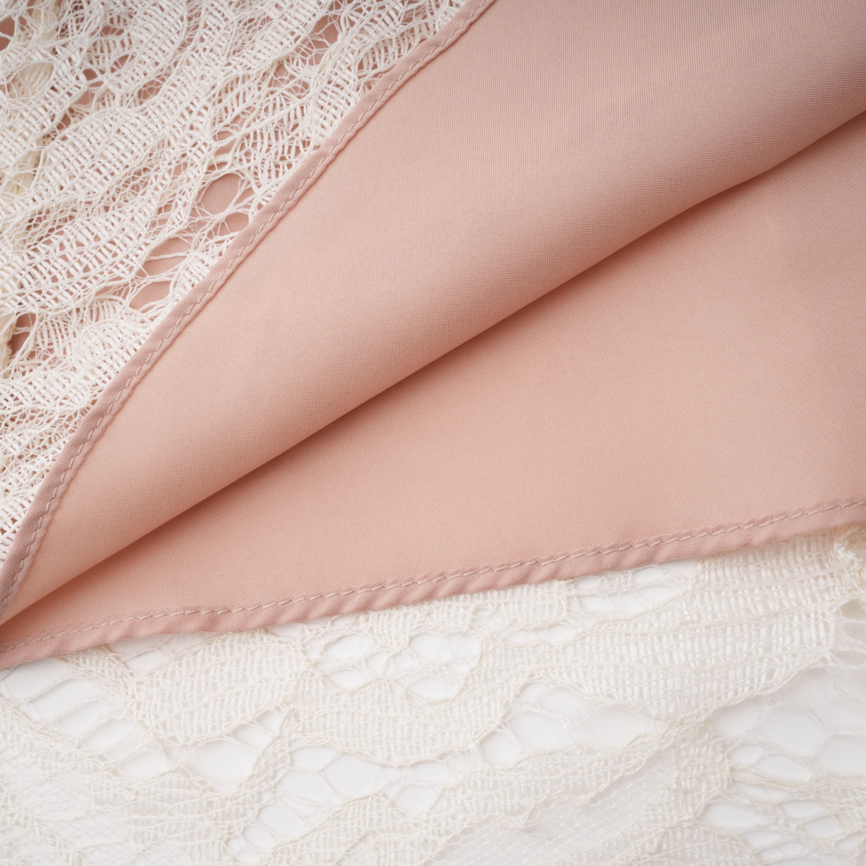 فستان ميدي أبيض من Alaia بتصميم رداء وطبعة زهور من الدانتيل