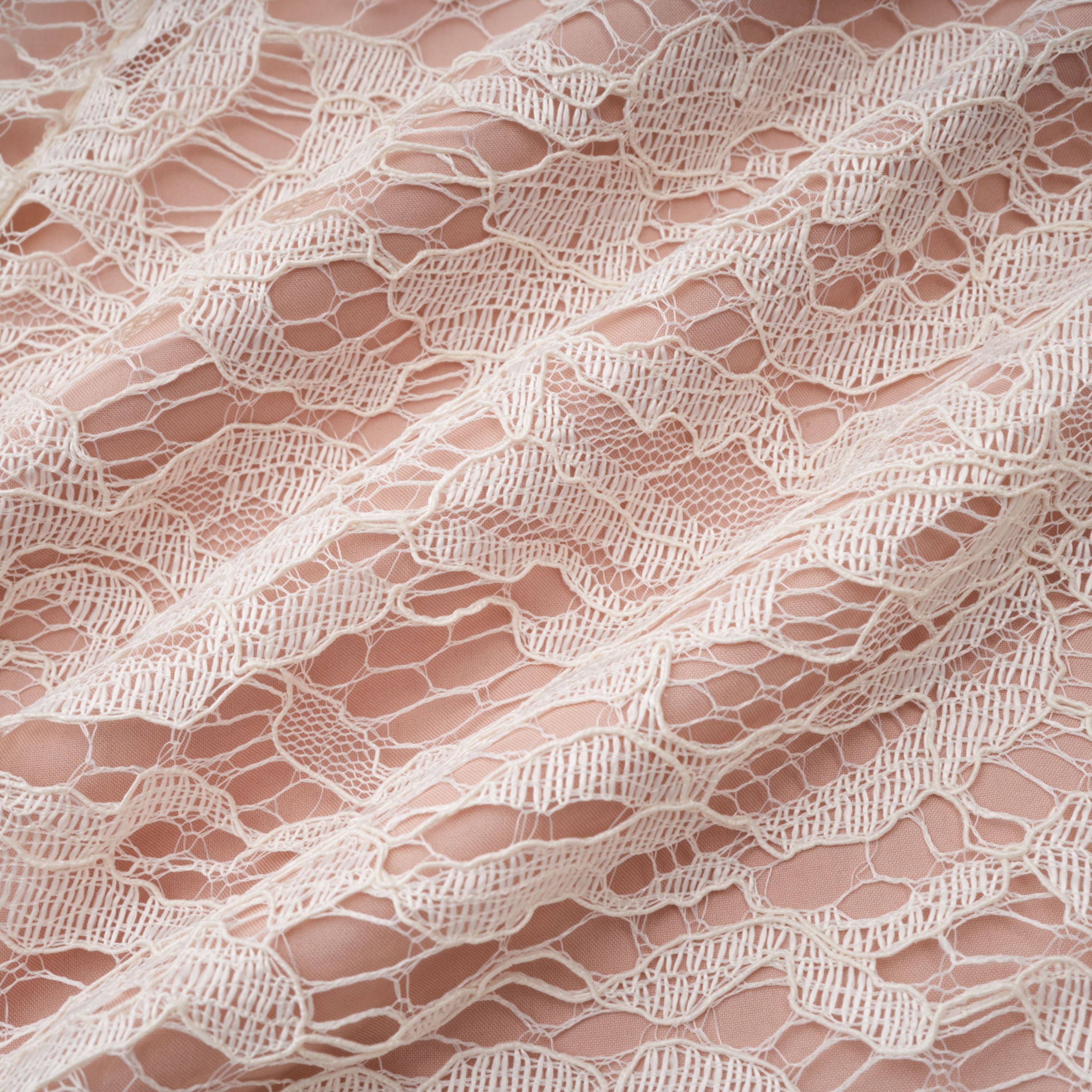 فستان ميدي أبيض من Alaia بتصميم رداء وطبعة زهور من الدانتيل