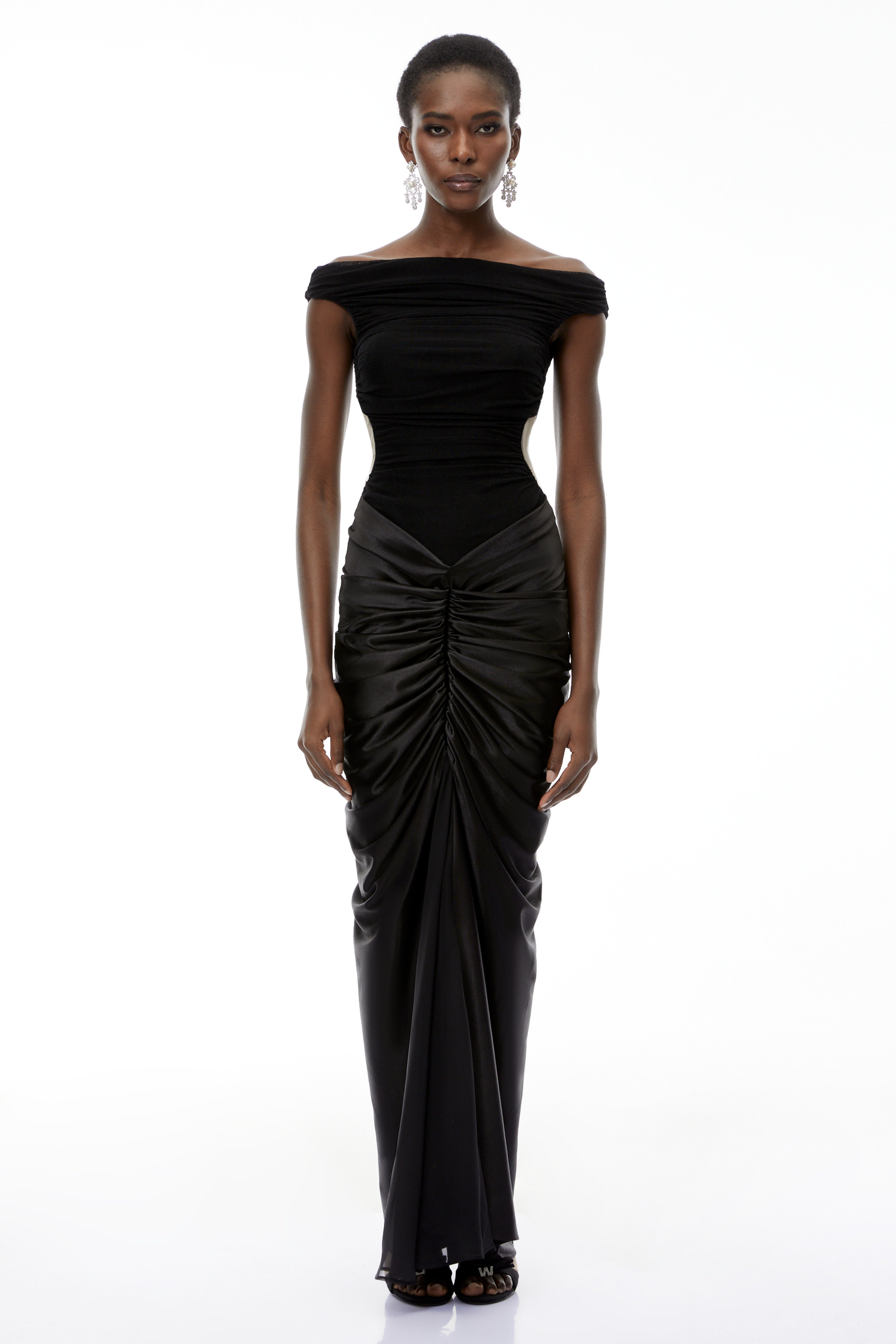 فستان طويل من إيدن باللون الأسود، مكشوف الكتفين ومزين بكشكشة