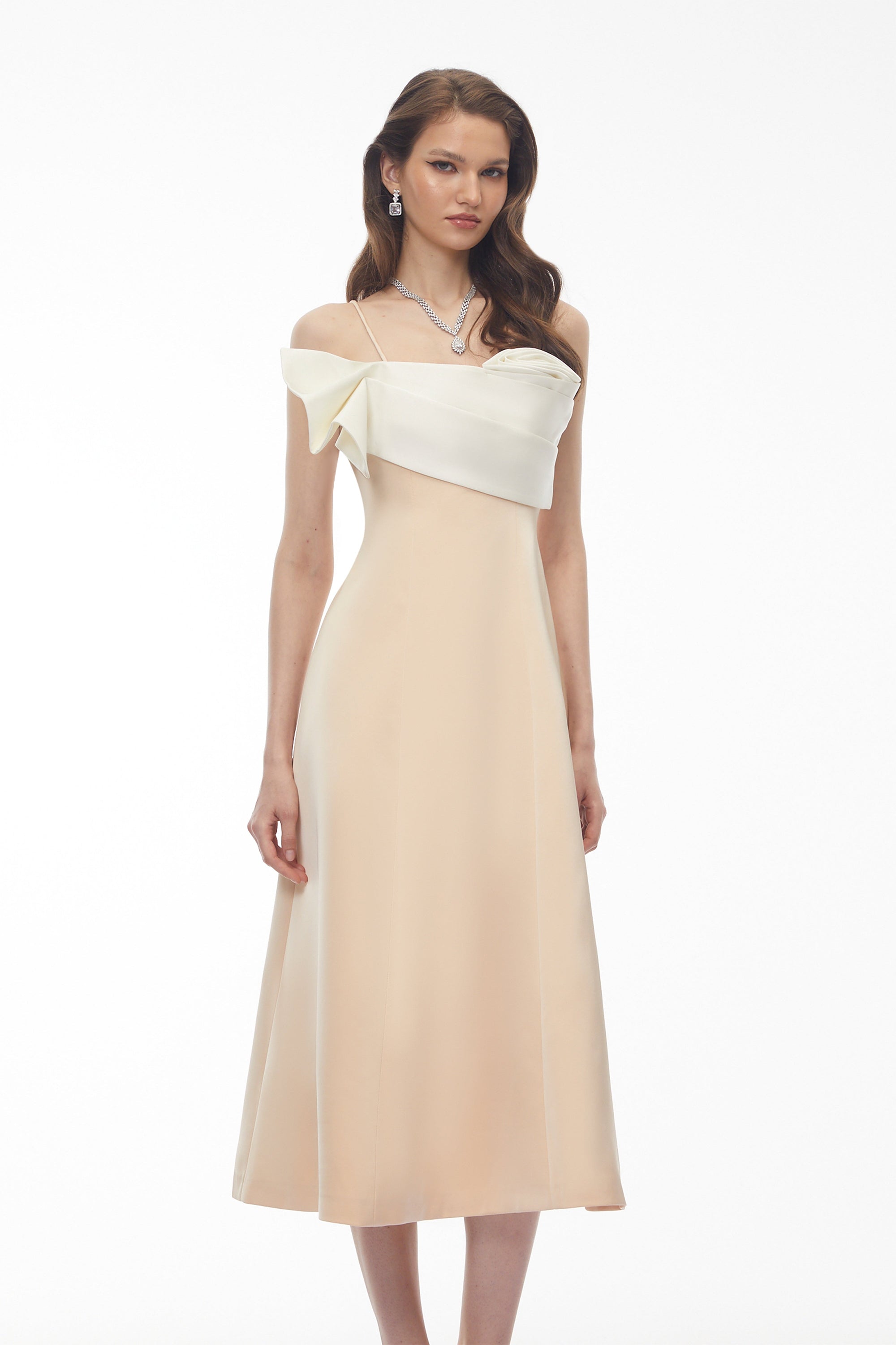 Robe midi couleur crème, avec un corsage sculptural en satin blanc et une fine bretelle