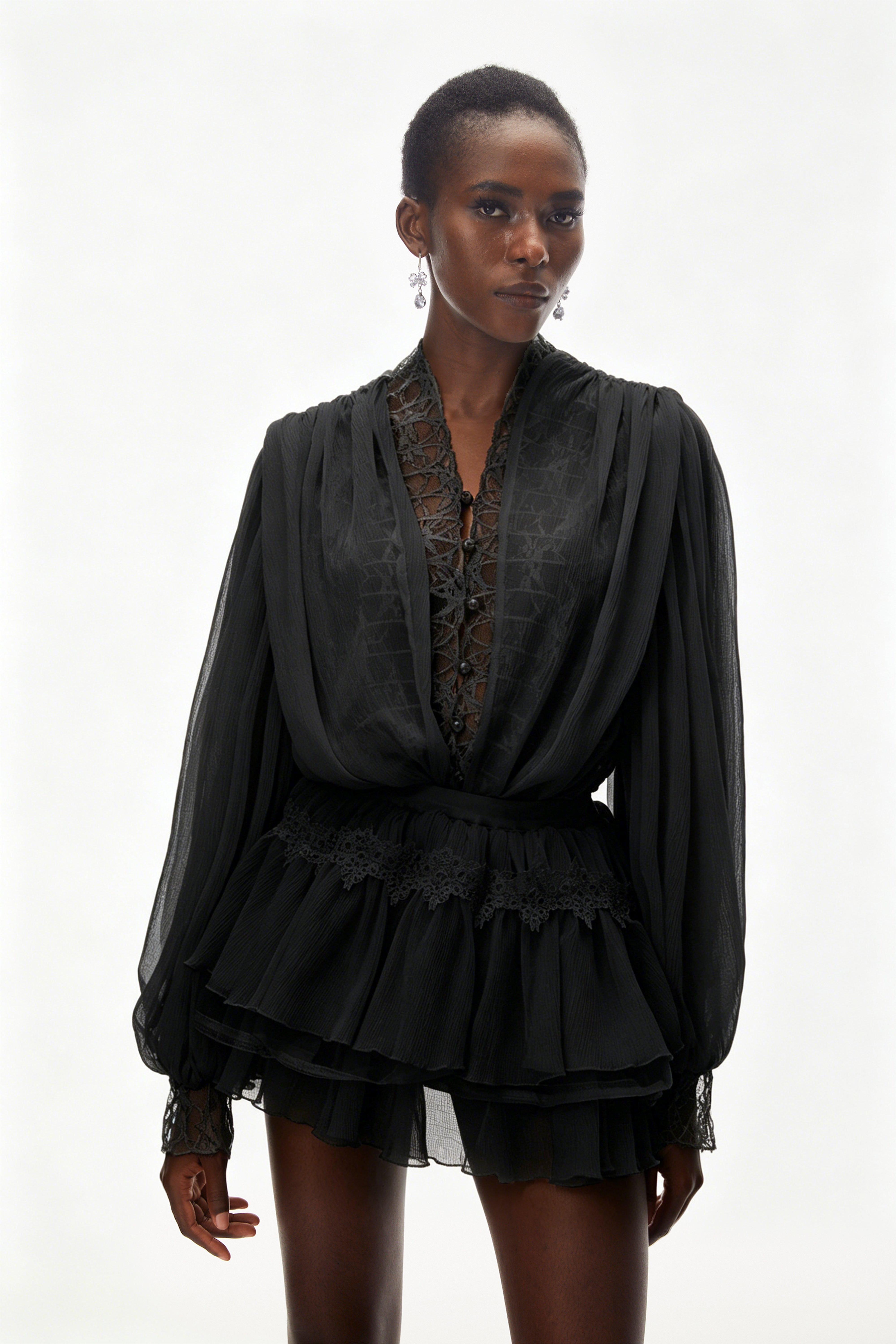 Ensemble composé d'un chemisier noir à bordures en dentelle et d'une jupe à volants