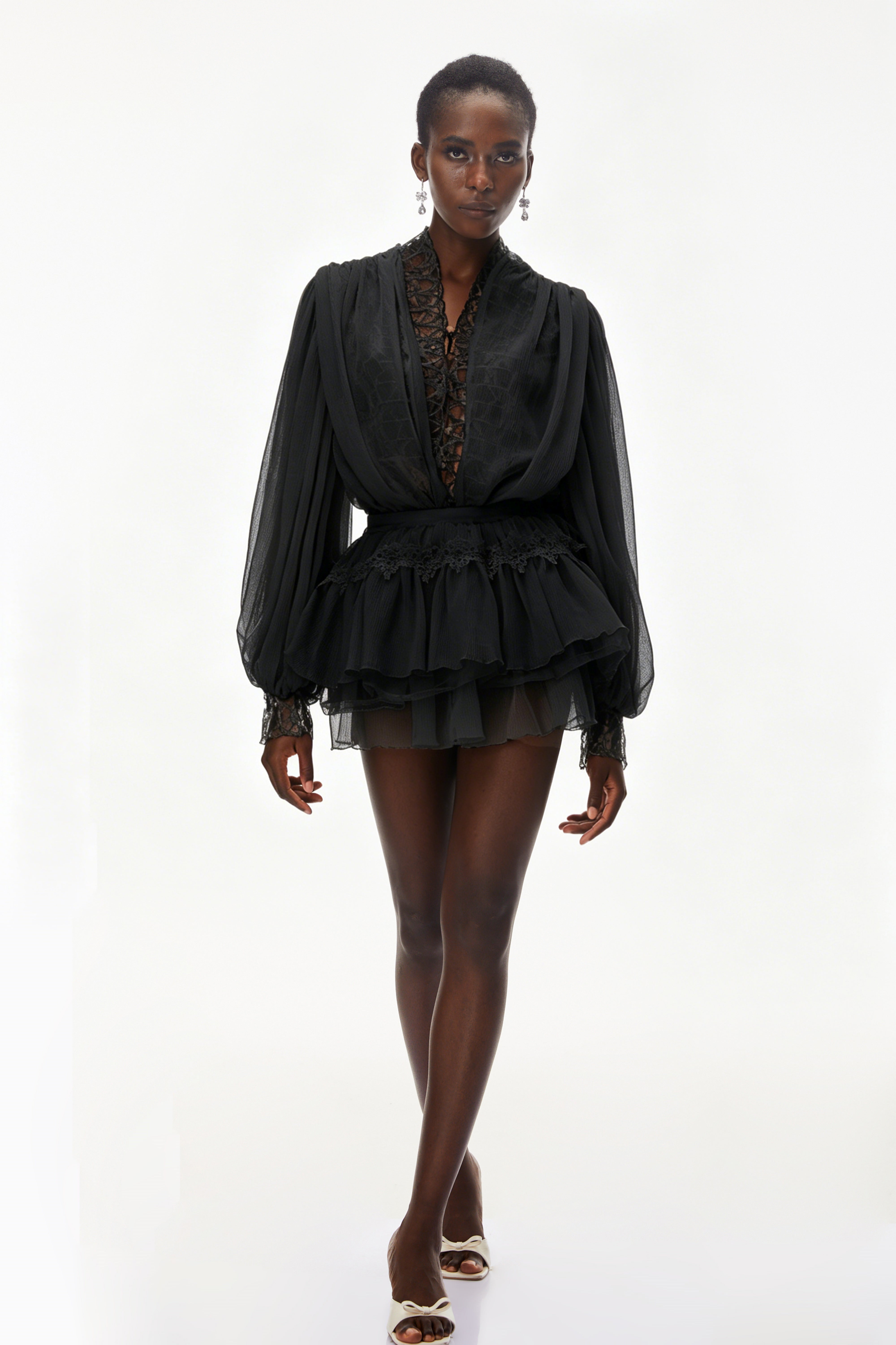 Ensemble composé d'un chemisier noir à bordures en dentelle et d'une jupe à volants